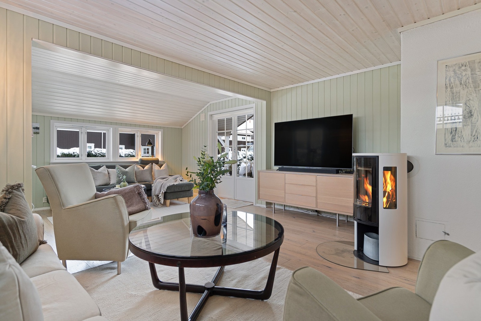 Store vindusflater slipper inn rikelig med naturlig lys og skaper en trivelig atmosfære. Galleribilde