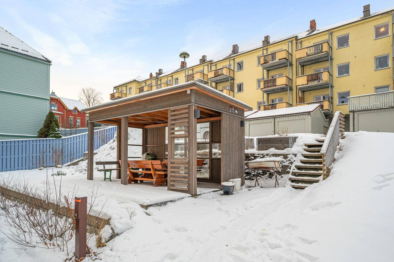 Felles uteplass med takoverbygg og sittegrupper, godt egnet for både hverdagsbruk og sammenkomster. Galleribilde