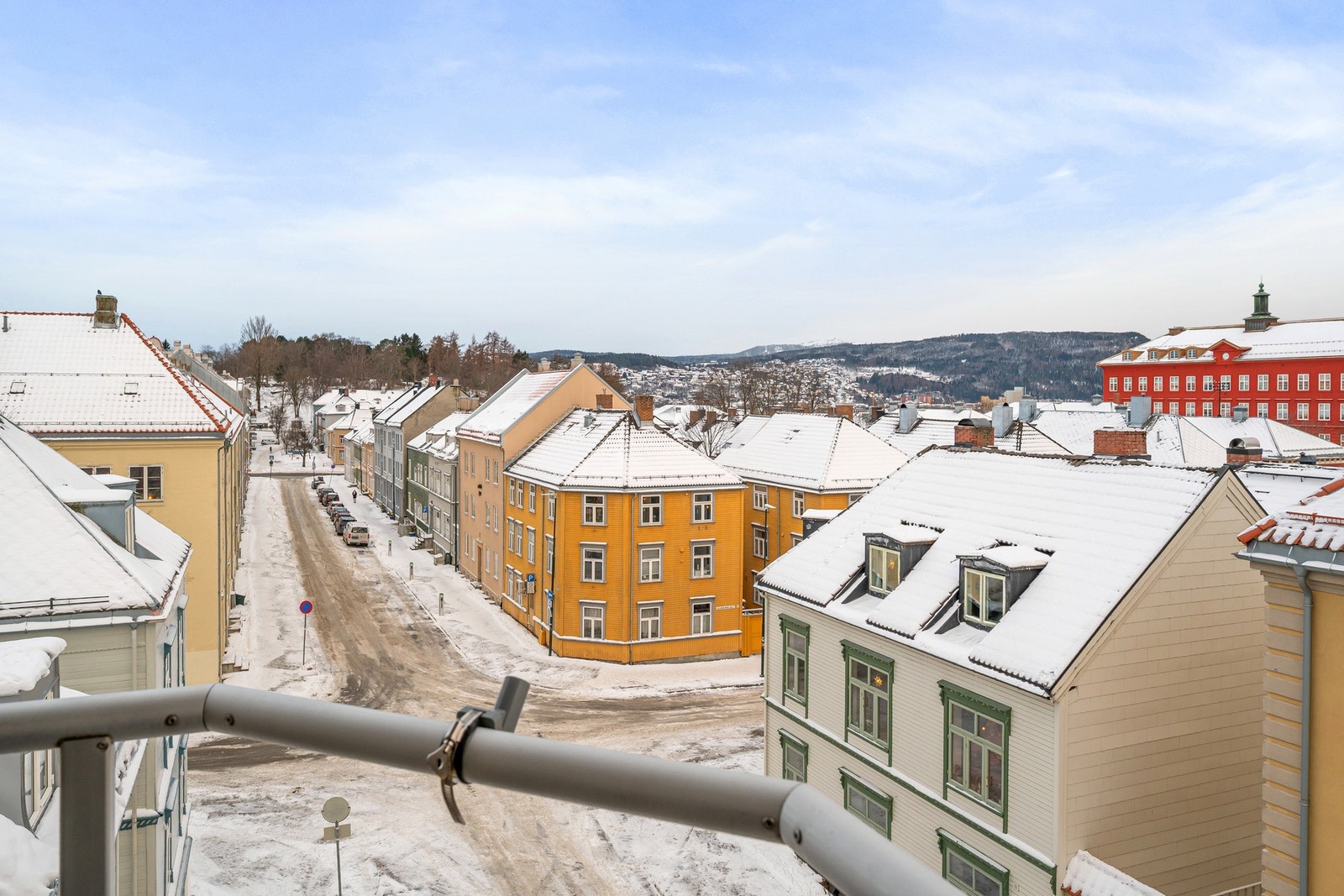 Utsikt fra balkong mot trivelig bybebyggelse og nærområdet. Galleribilde