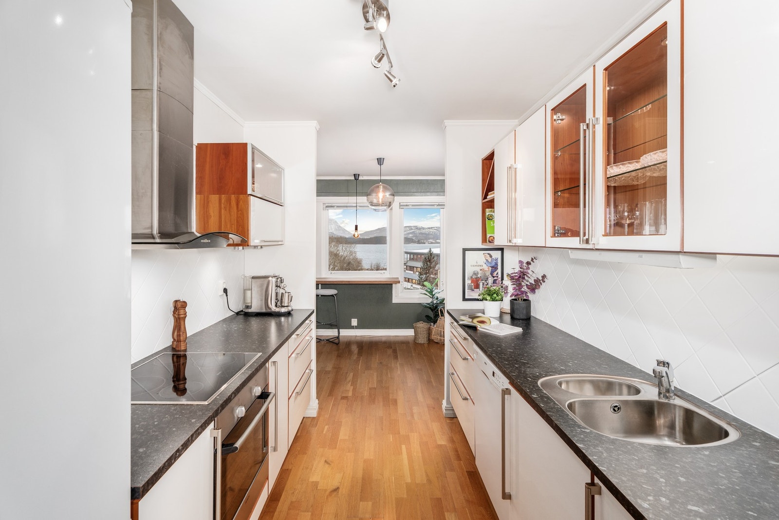 Lyst og pent på kjøkkenet og vinduene mot syd gir mye naturlig lys inn. Plass for spisegruppe, sofa eller barkrakker ved vinduene. Galleribilde