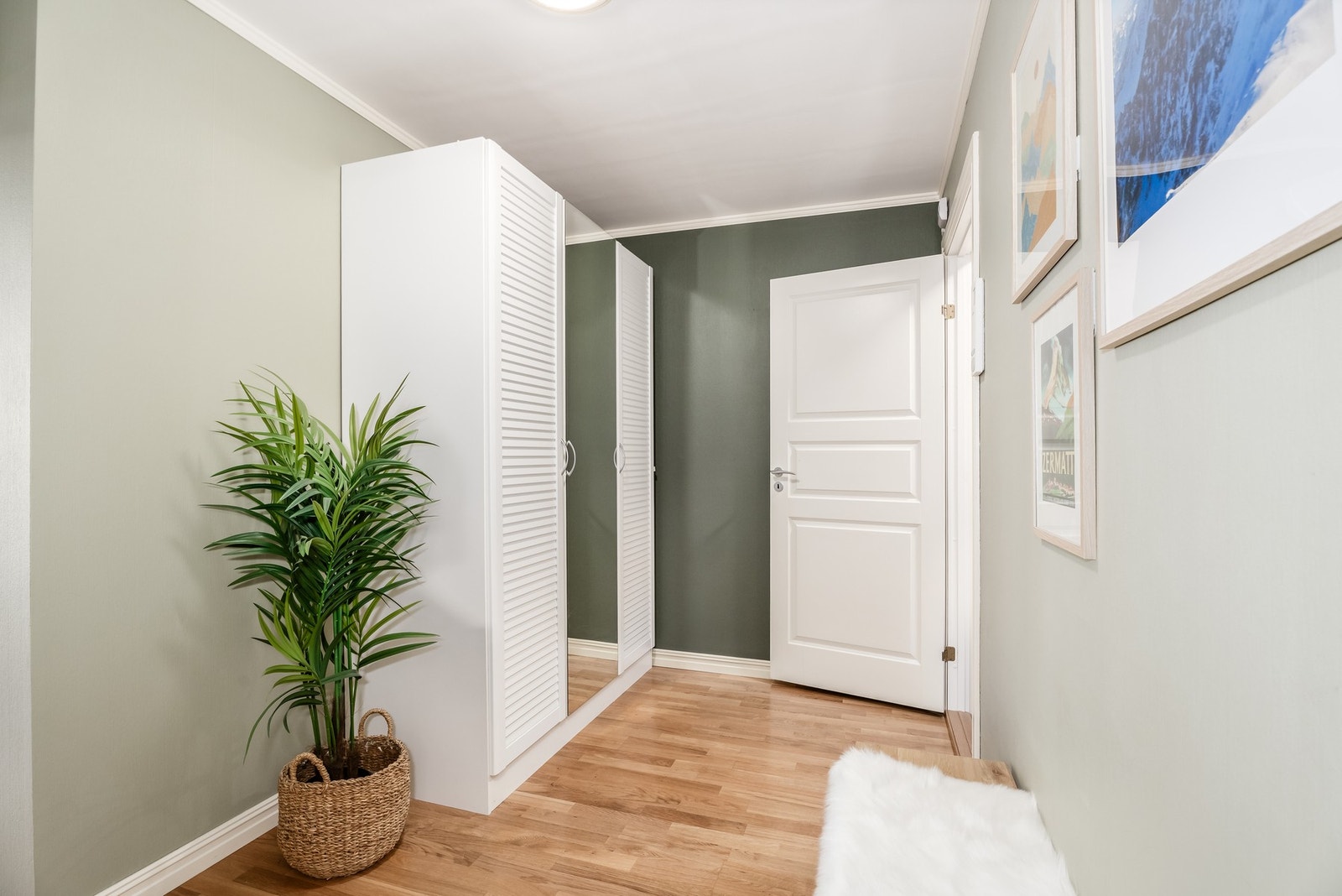 Gangen er lys og delikat. Selger har valgt å ha garderobeskap foran dør som går til vaskerom og bod. Galleribilde