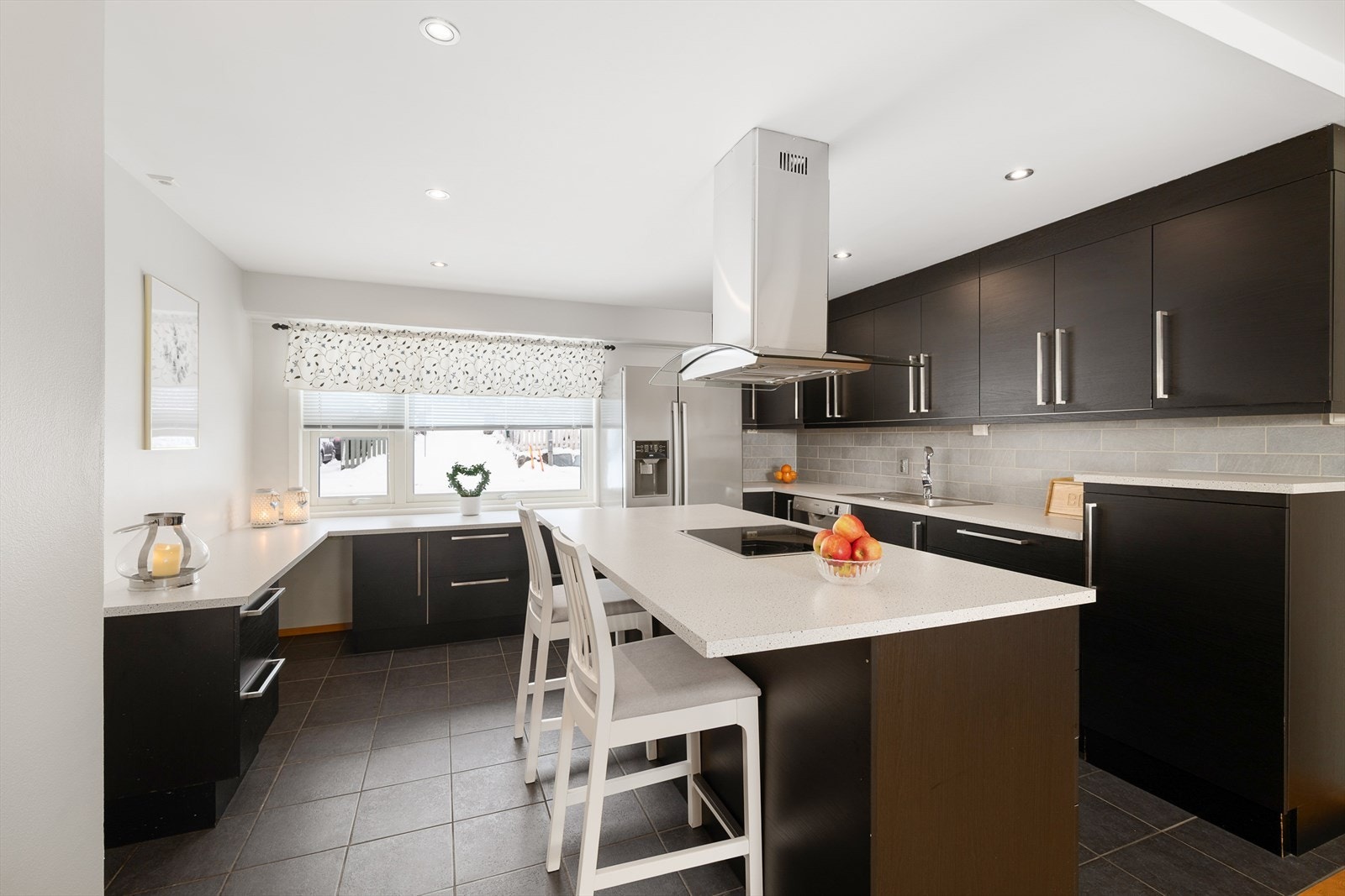 Kjøkkenet fra 2012 har en moderne innredning med svarte, glatte fronter og fliser på gulv. Galleribilde