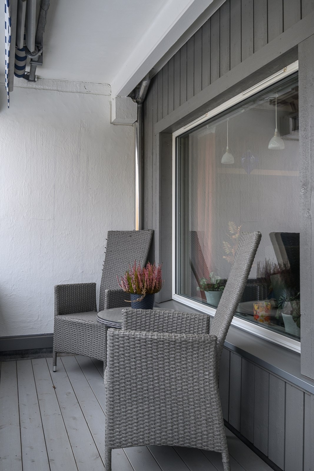 Rekkverk i stål og tre strekker seg foran hele leiligheten og rammer inn uteplassen. Galleribilde