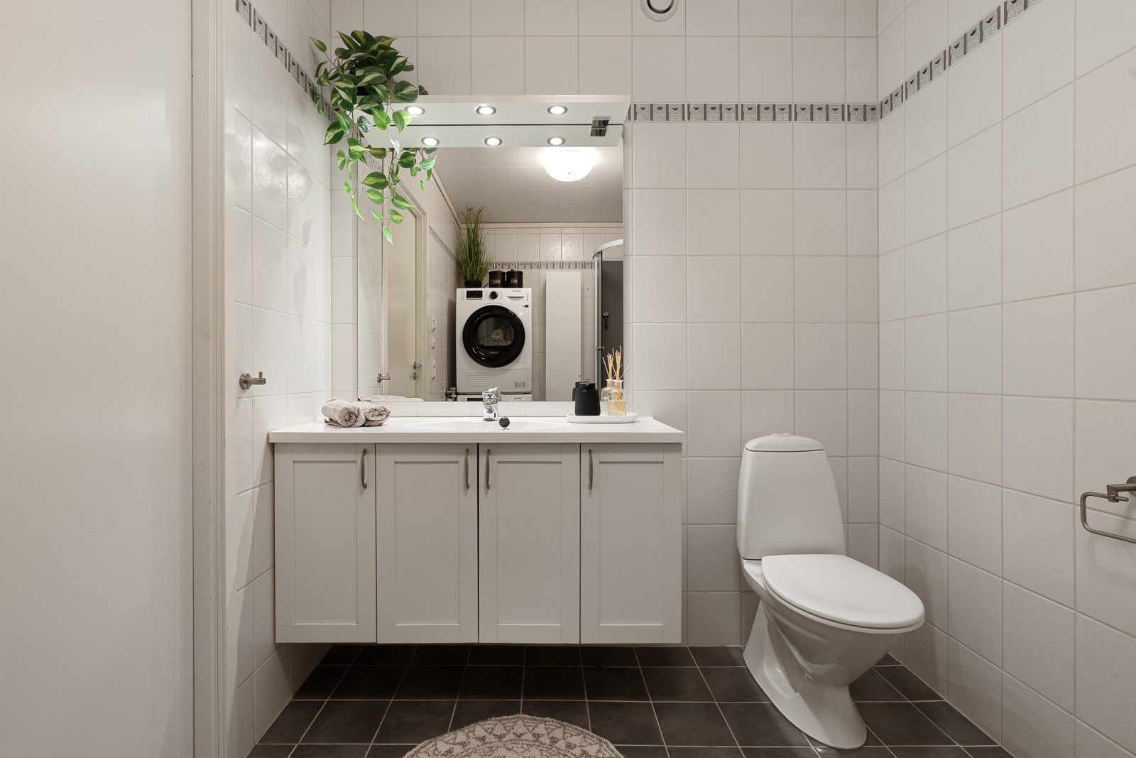 Flislagt bad med varme i gulv og lys baderomsinnredning. Galleribilde