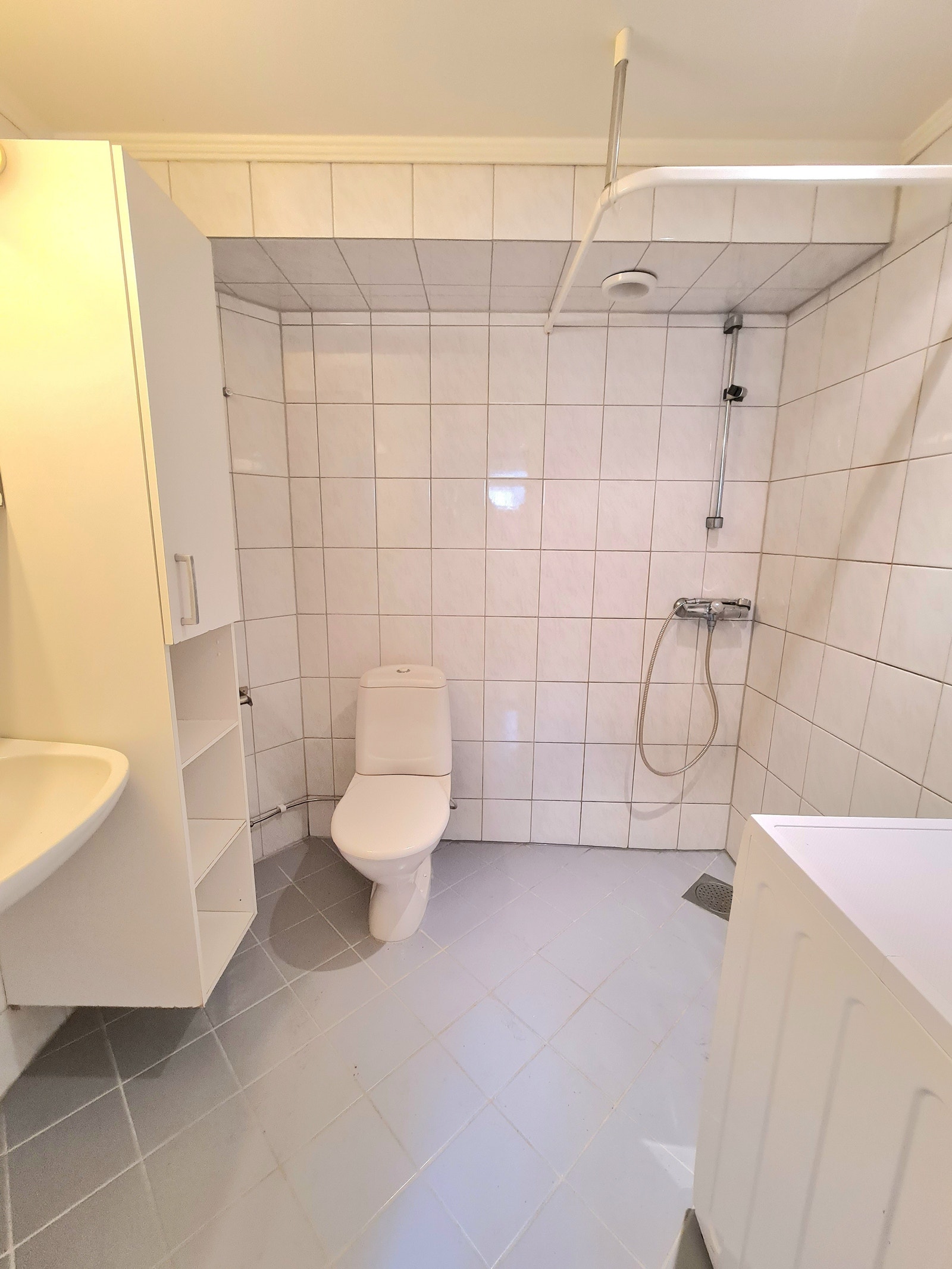 Romslig bad med lyse fliser og mye skapplass, opplegg for vaskemaskin, dusjvegger nå installert Galleribilde