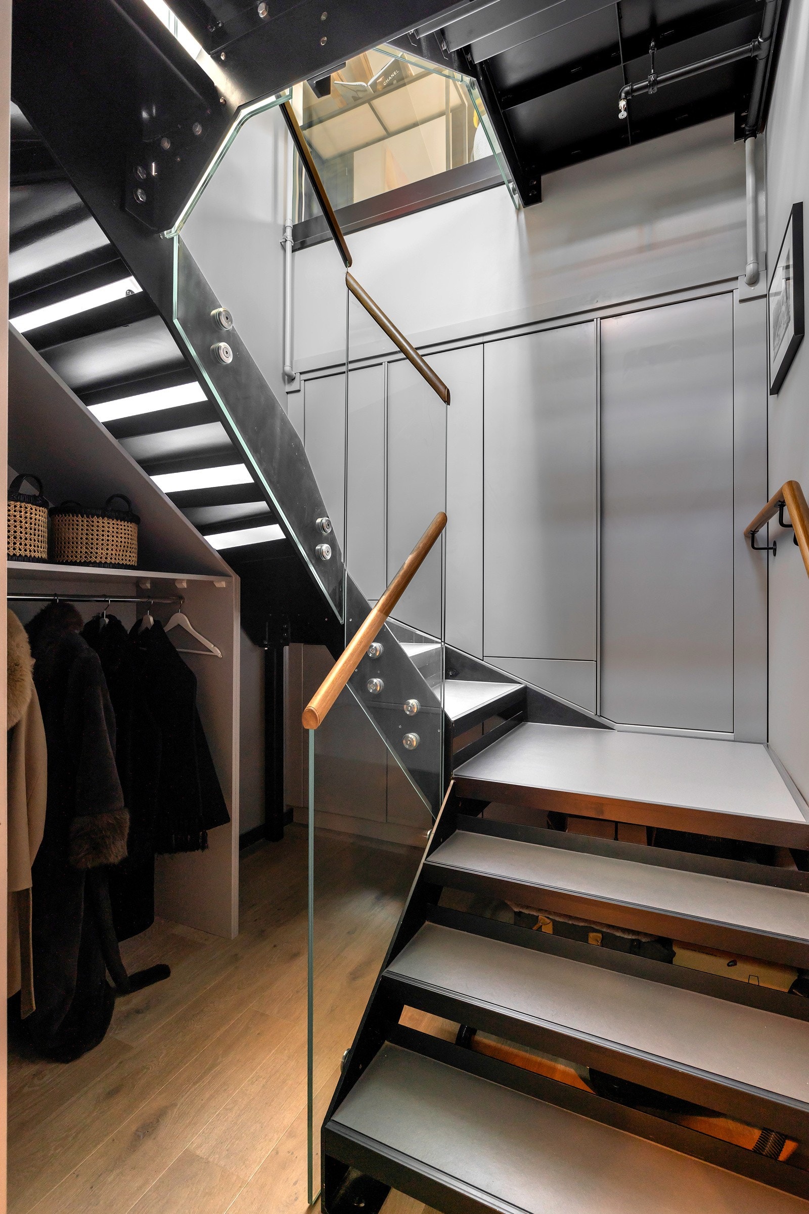 Leiligheten har en innbydende entré som har snekkertilpasset garderobeløsning under trapp og garderobeskap i trappen, som gir god plass til oppbevaring av sko og yttertøy Galleribilde