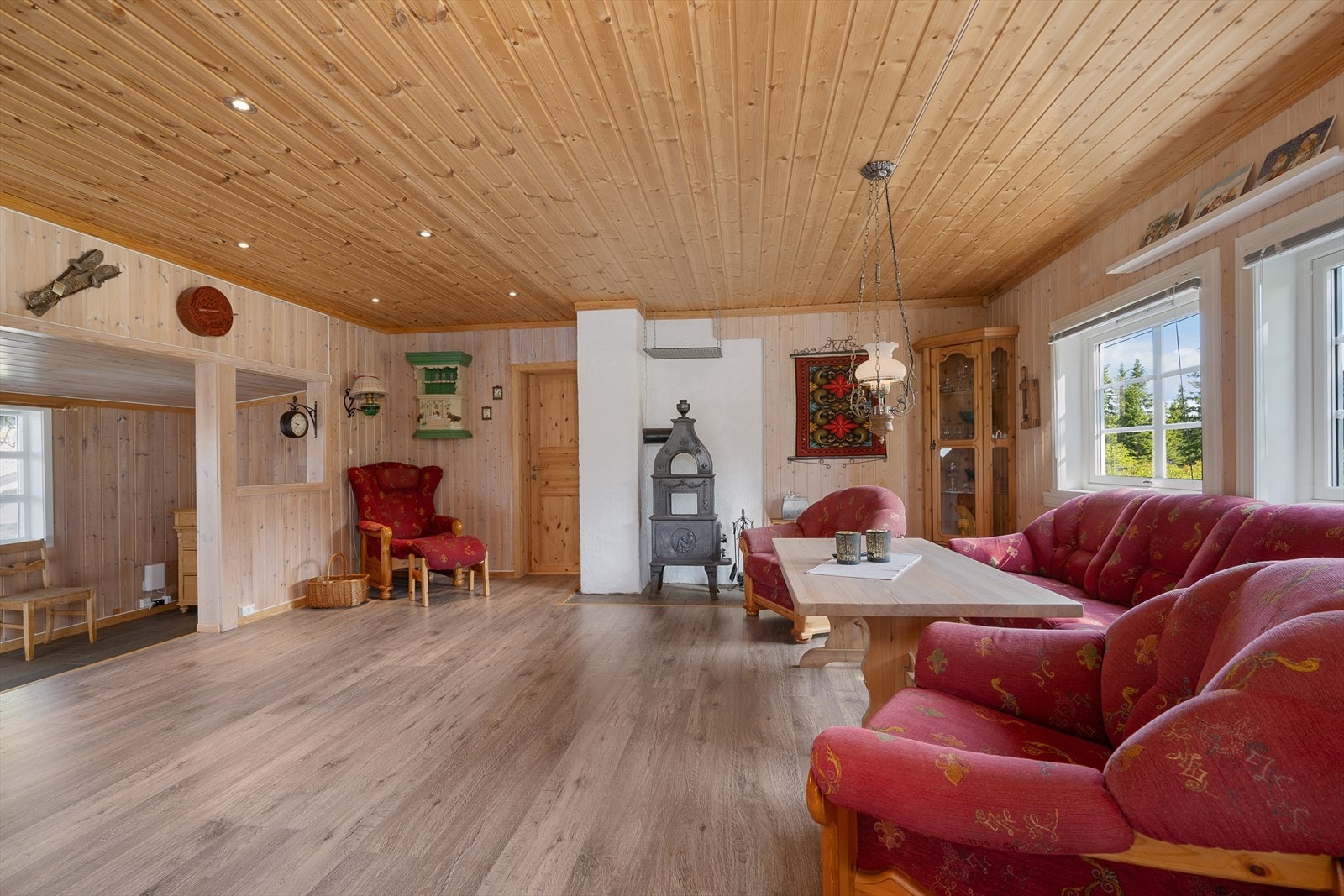 Oppholdsrommet har en åpen løsning mot inngangen. Dette gjør rommet lyst og luftig. Det er spotter i taket, panelte vegger og nyere laminat gulv. Galleribilde