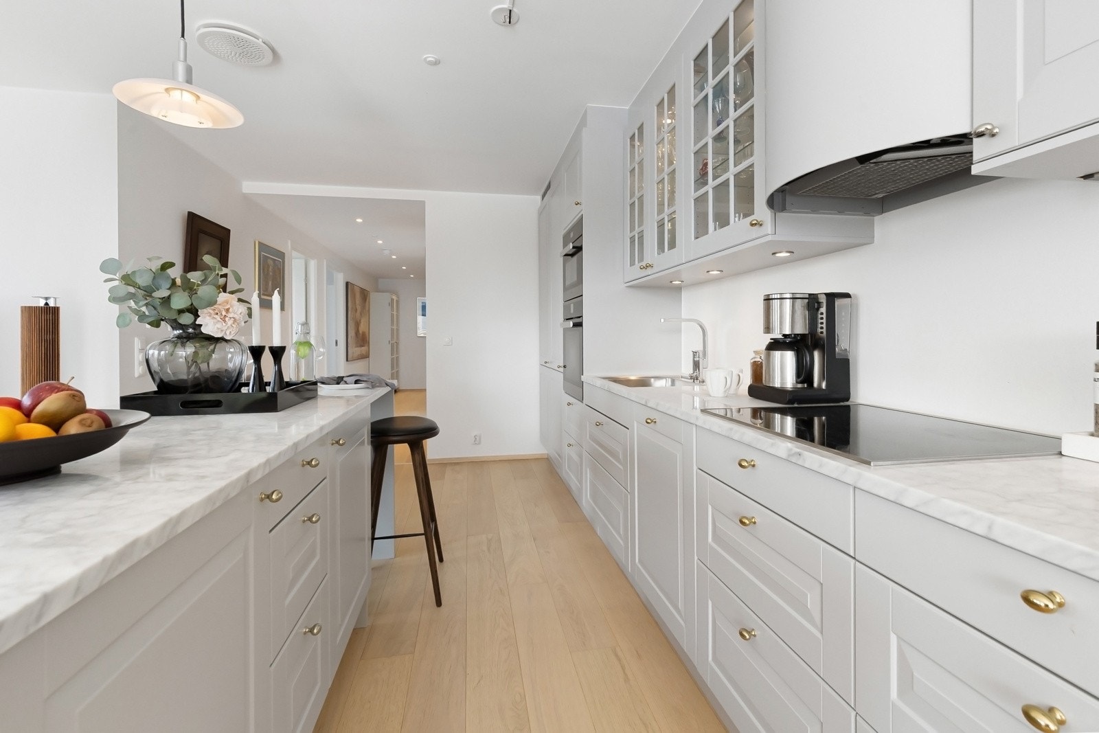 Det er godt med oppbevaringsplass og det er belysning over kjøkkenbenken og i hyllene Galleribilde