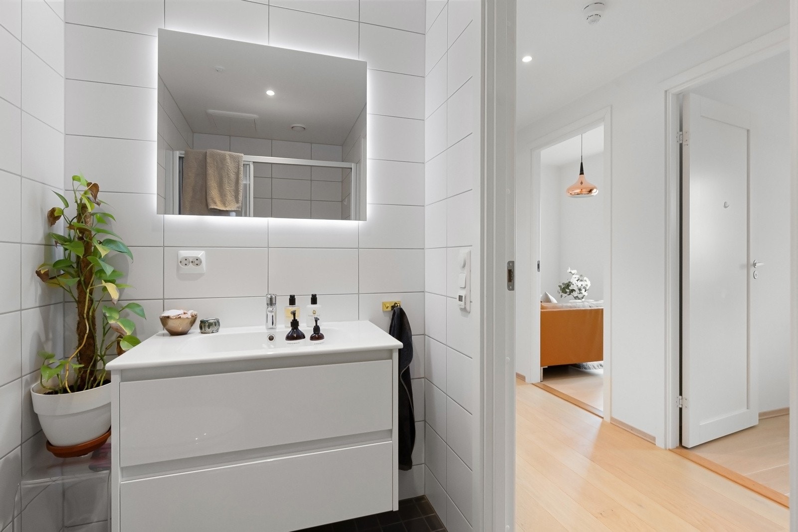 Baderommet i tilknytning til entréen er innredet med servant med slette fronter, vegghengt toalett og dusjhjørne Galleribilde