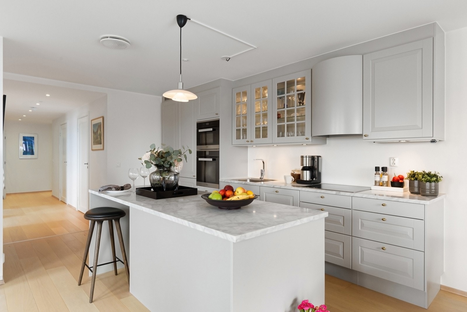 Kjøkkeninnredning fra Norema er fra 2017 og har profilerte fronter, benkeplate av stein og oppvaskkum av stål Galleribilde