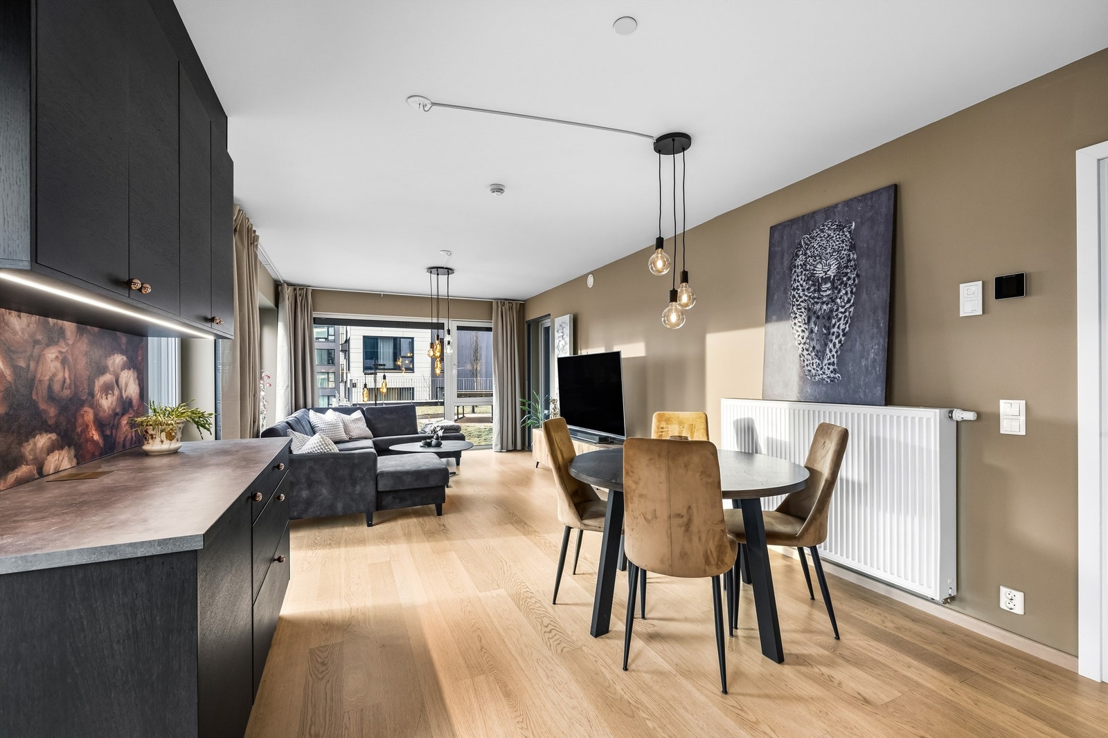 Den åpne løsningen mellom stue og kjøkken skaper en sosial og luftig atmosfære. Galleribilde