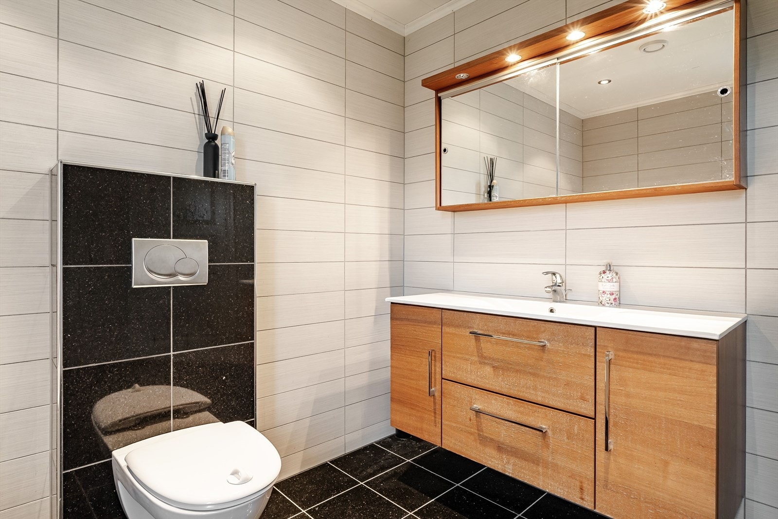 Badet inneholder badekar, dusjkabinett, vegghengt toalett og helstøpt servant Galleribilde