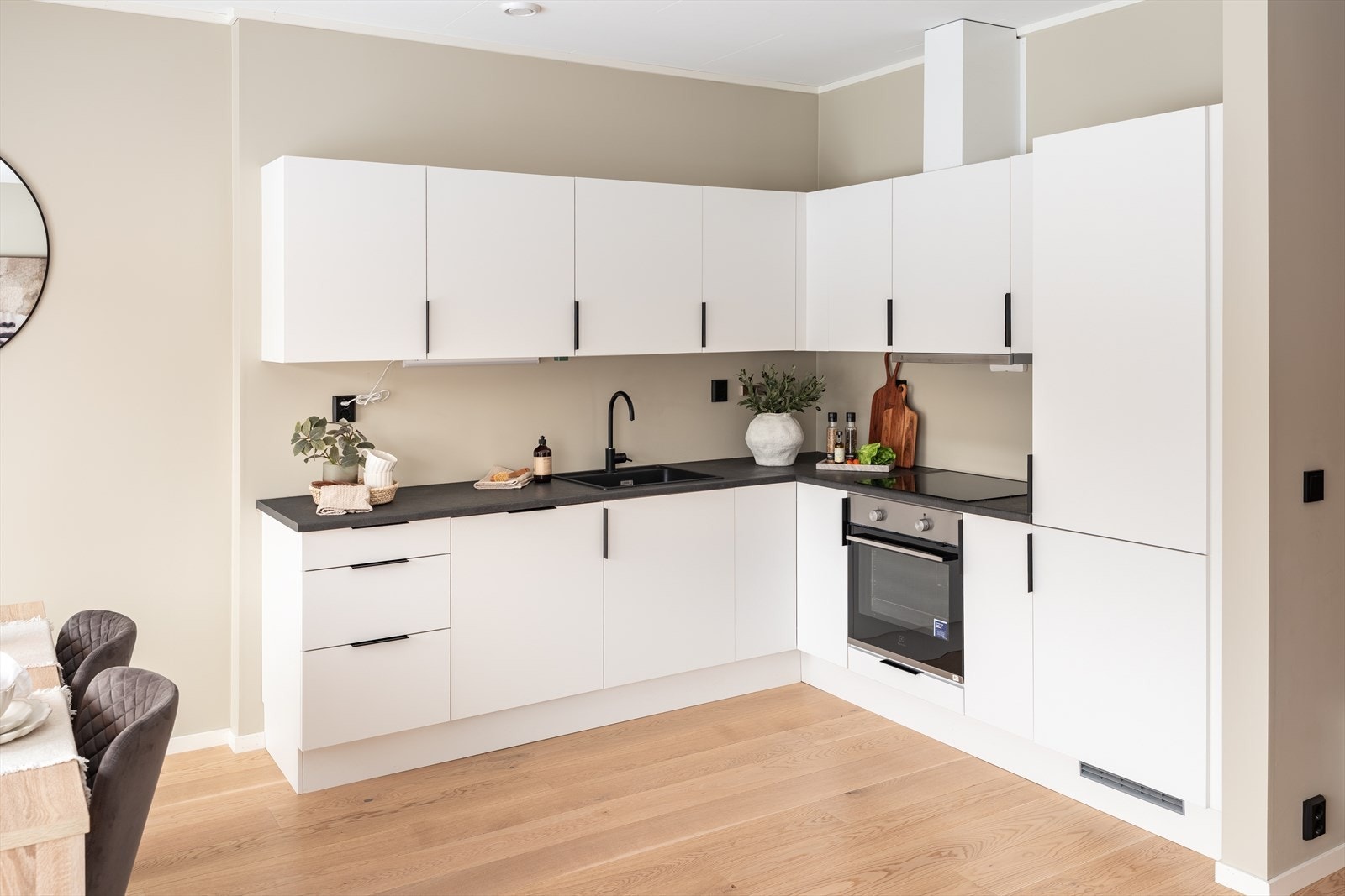 Lys og fin kjøkkeninnredning med folierte skrog med slette fronter og laminert benkeplate. Galleribilde