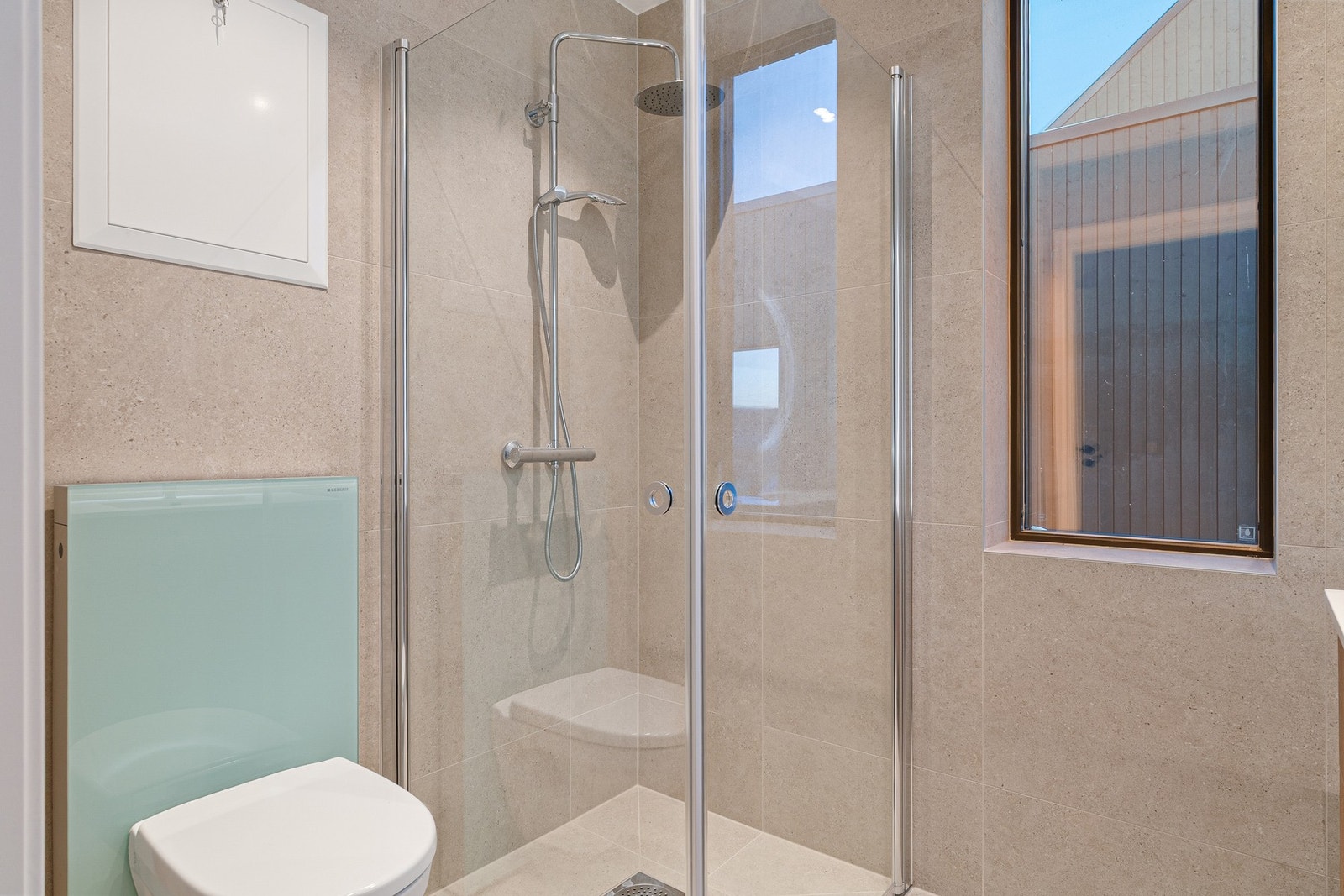 Dusj/regndusj med innfellbare glassvegger. Vegghengt toalett. Galleribilde