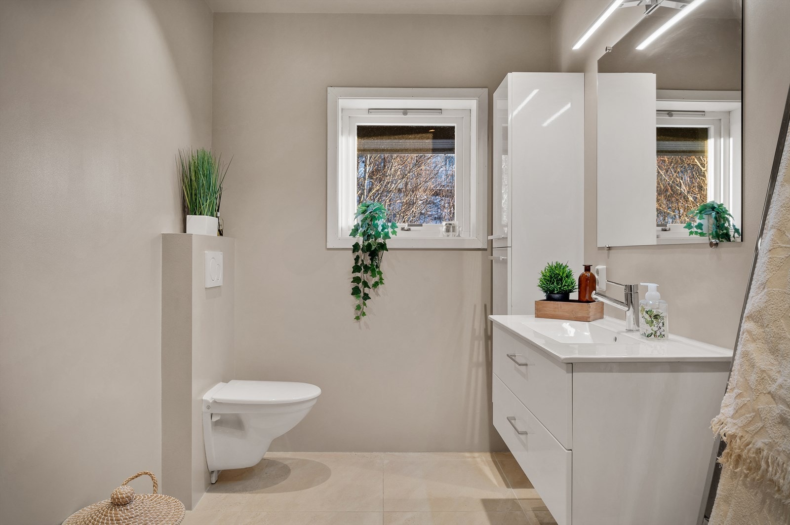 - Badet er innredet med vegghengt toalett, benkeskap med servant og innfellbare dusjdører i glass - Galleribilde