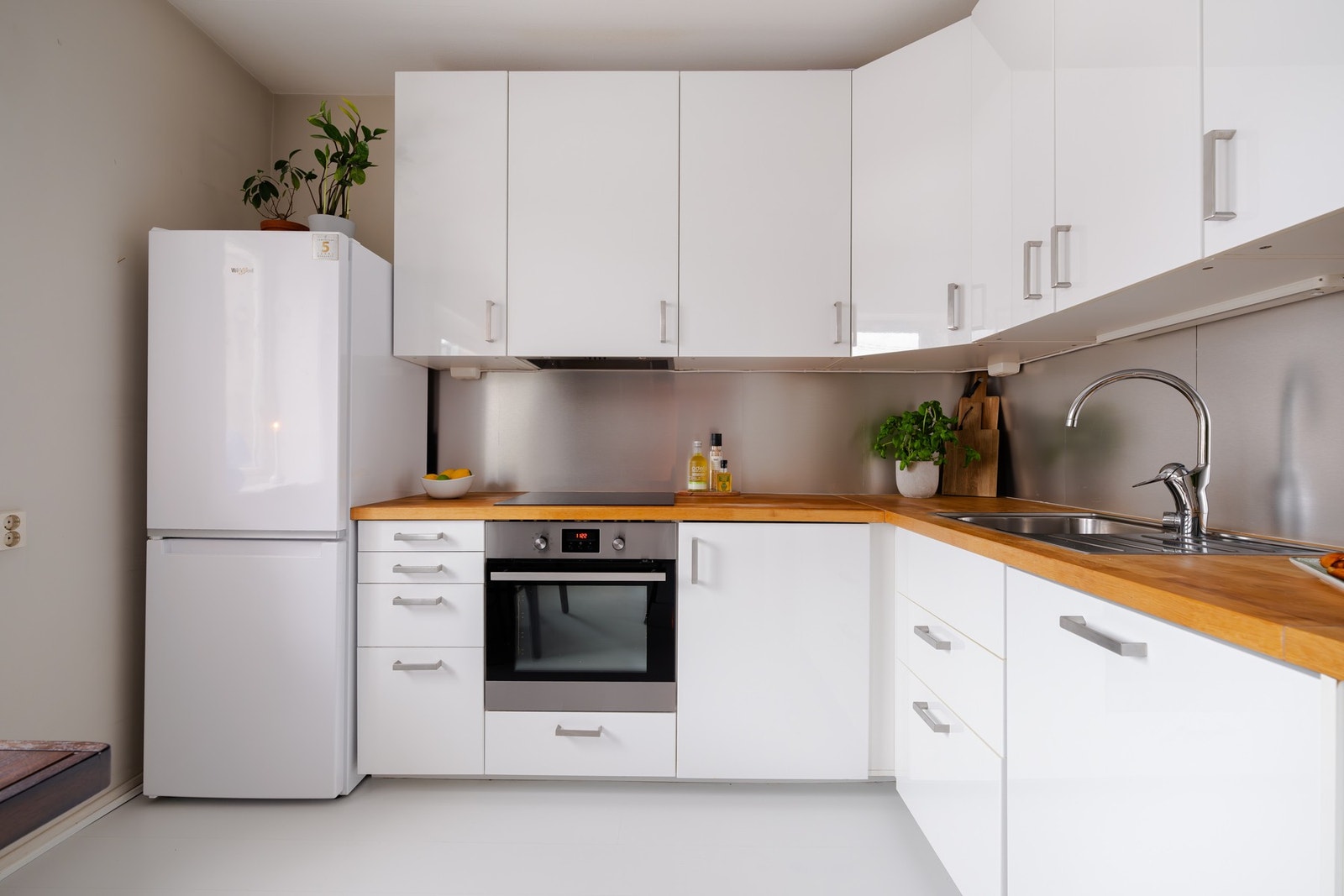 Lys, glatt innredning med heltre benkeplate og kompositt oppvaskkum med blandebatteri i rustfritt stål. Galleribilde