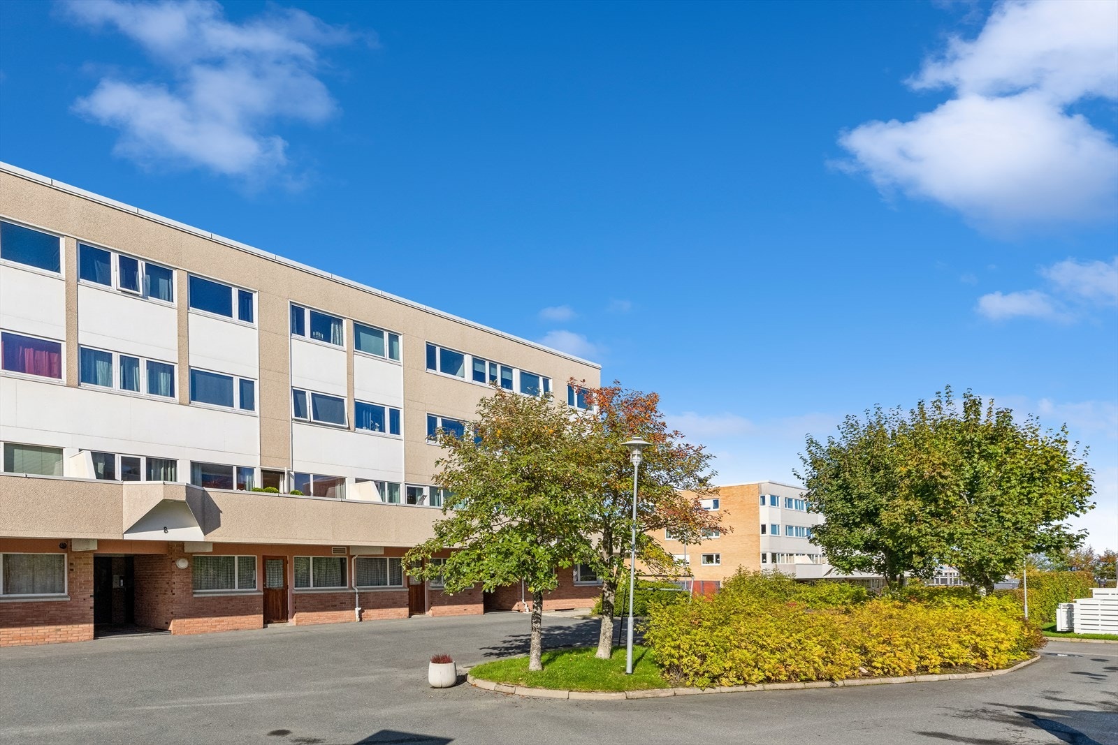 Borettslagets tomt er pent opparbeidet med plenareal, sittegrupper, busker og trær. Leiligheten disponerer fast parkeringsplass i underjordisk parkeringskjeller. Galleribilde