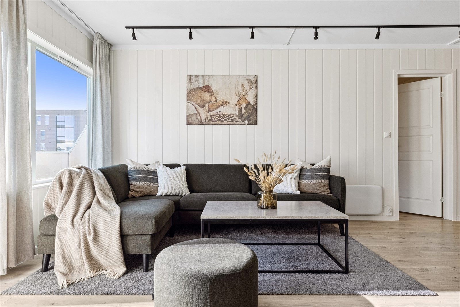 Leilighetens stue fremstår som luftig på 26 m² med rom for ulike møbleringsmuligheter, og god plass en en større sittegruppe. Galleribilde