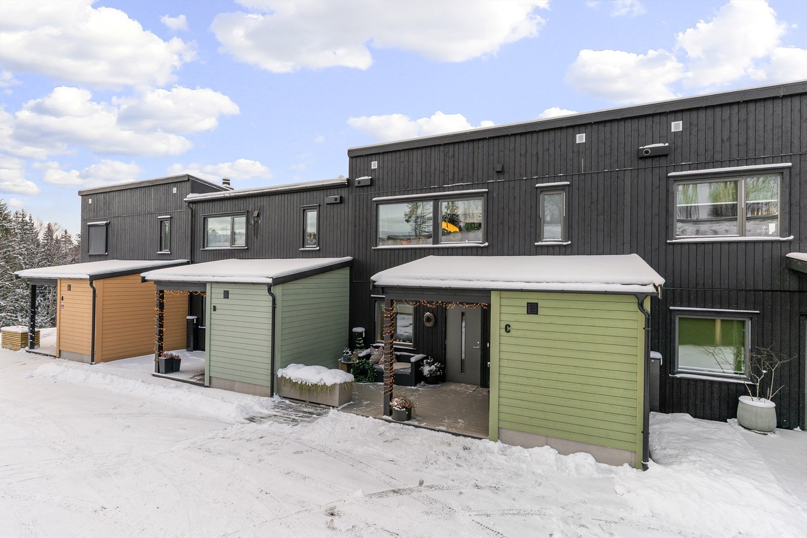 Boligen ligger som den 3. innerste i hele rekka, og hver bolig har et eget, skjermet inngangsparti - her med påkostet platting og sportsbod til høyre. Galleribilde