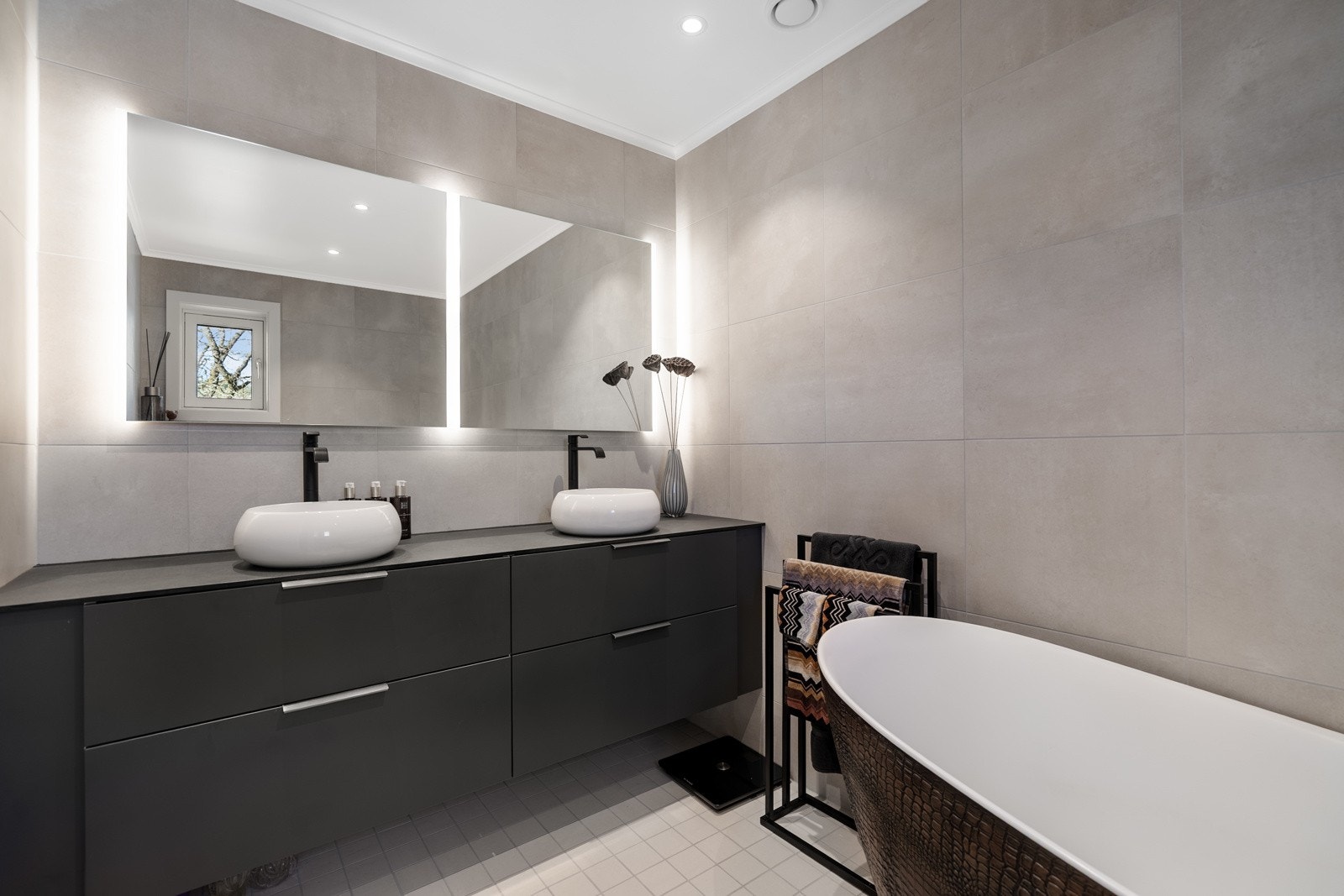 Badet har delikate fliser, varme i gulv og nydelig badekar med krok struktur Galleribilde