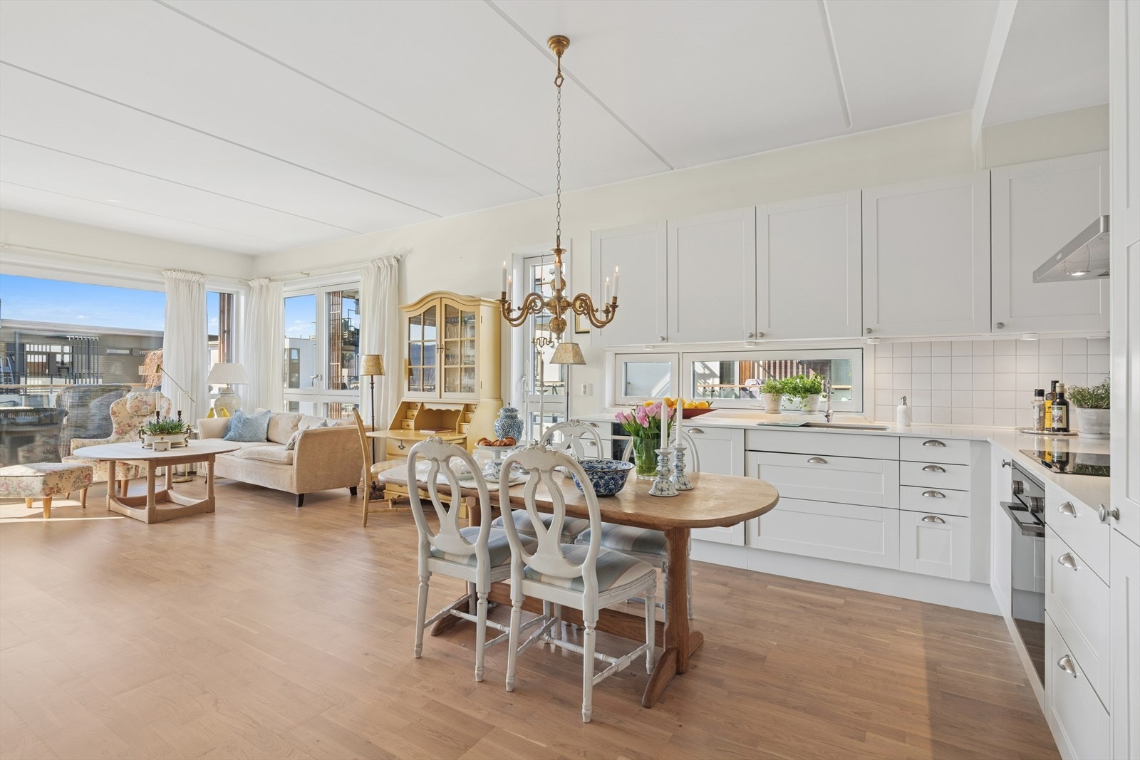 Kjøkkenet er lyst og innbydende, med hvite, profilerte fronter som gir et klassisk og tidløst utseende. Galleribilde