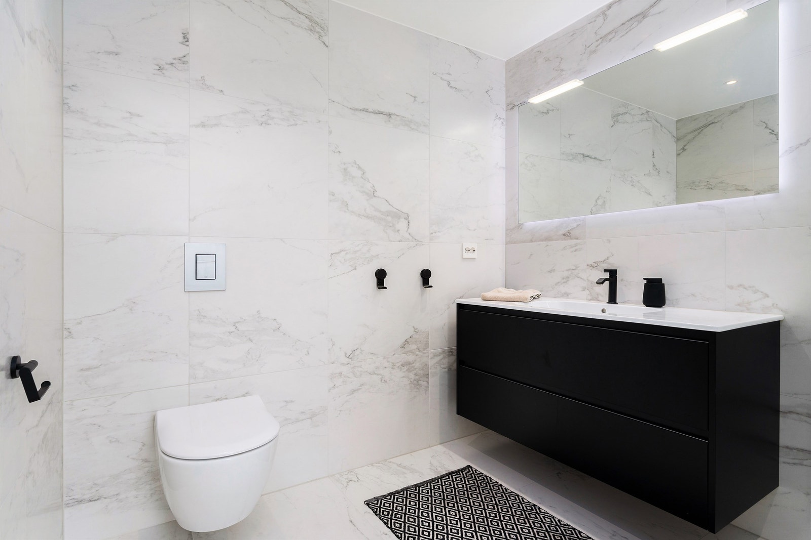 God baderomsinnredning som komplementeres med vegghengt speil og integrert belysning. Toalettet er fra Villeroy & Boch i tillegg har badet Devismart termostatstyring med mulighet for appstyring Galleribilde