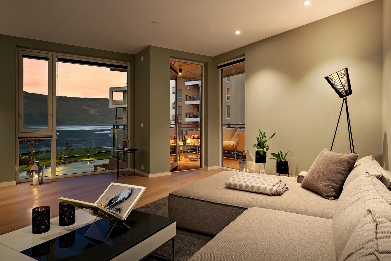 Fra tv-hjørnet er det store vindusflater som gir en nydelig utsikt mot fjorden både dag- og kveldstid. Det er og direkte utgang til en av leilighetens to balkonger Galleribilde