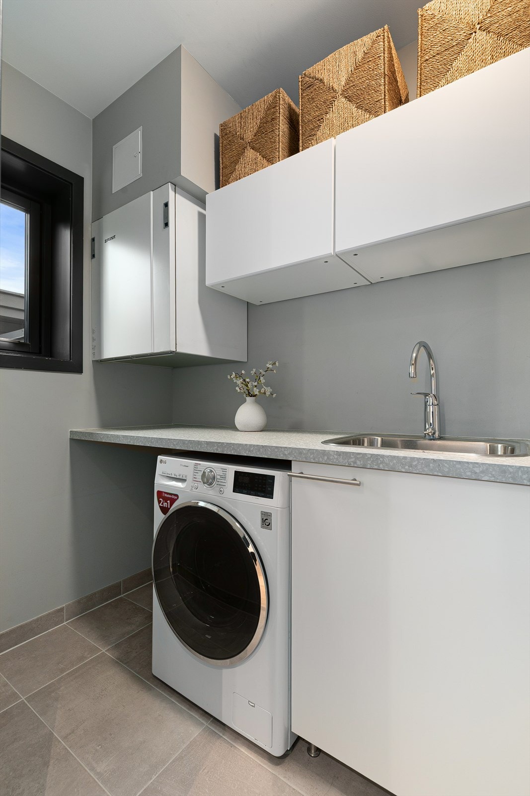 Praktisk vaskerom med mye oppbevaringsplass og opplegg for vaskemaskin Galleribilde