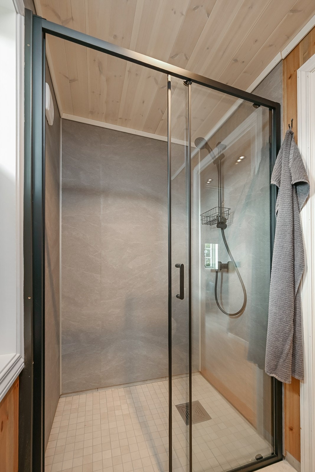 Flott dusj med fliser på gulv og baderomsplater på vegg. Glassvegger med svart omramming. Lekkert! Galleribilde