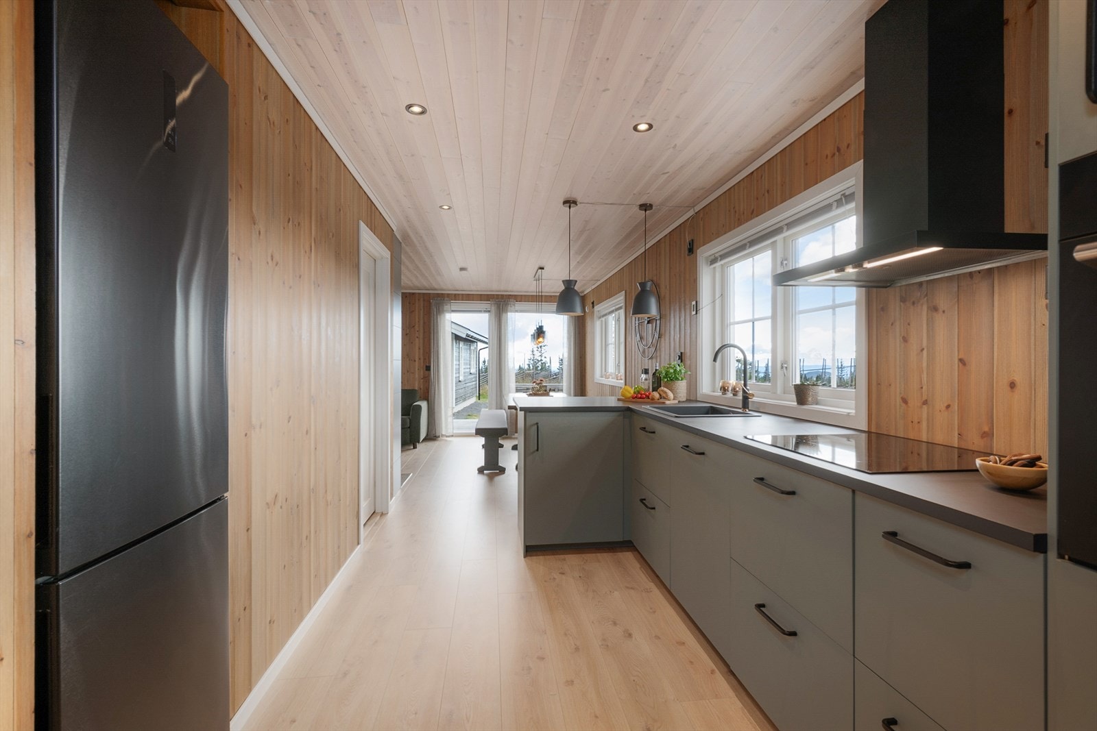 Kjøkkenet har innredning fra IKEA med glatte fronter i en delikat og smakfull grønntone. Vindu over kjøkkenbenken gir fint lys inn i rommet. Galleribilde