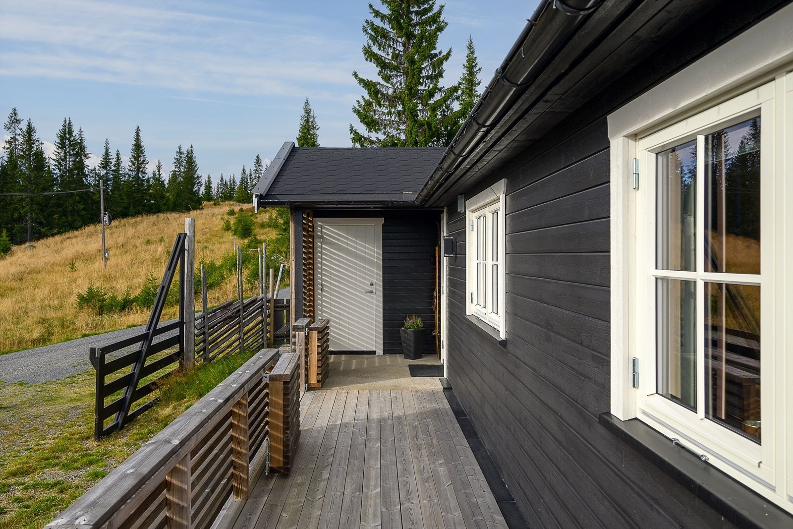 Terrassen fordeler seg på to sider av hytta og inkluderer inngangspartiet samt adkomst til boden. Galleribilde