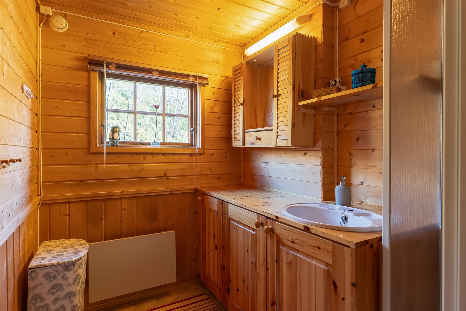 Badet måler 4 kvm og er innredet med servantskap og dusjkabinett. Galleribilde