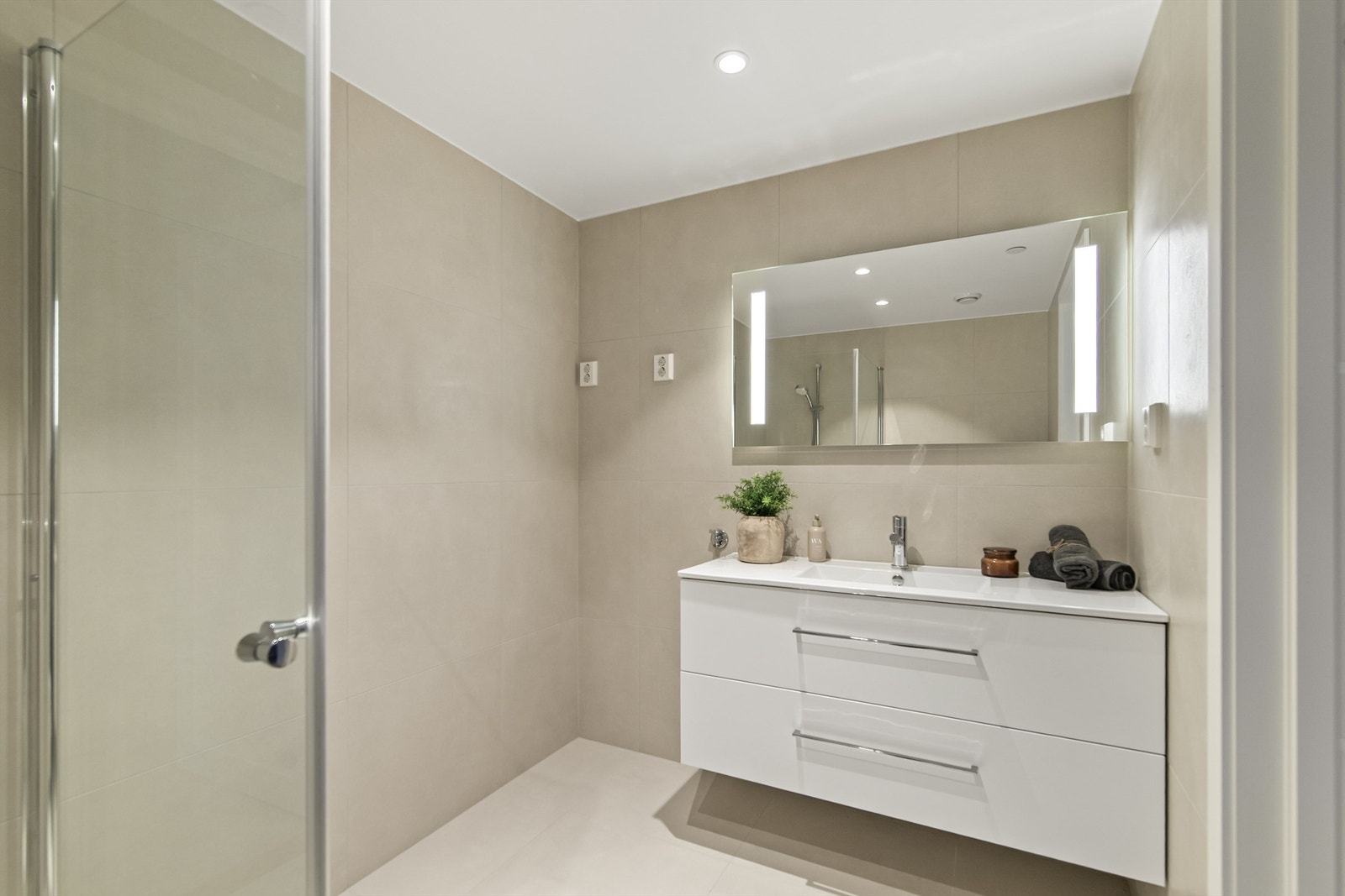 Leiligheten har flere elegante bad, hvor hovedsoverommet har sitt eget private bad/wc - en løsning som gir ekstra komfort og en følelse av privatliv i hverdagen Galleribilde