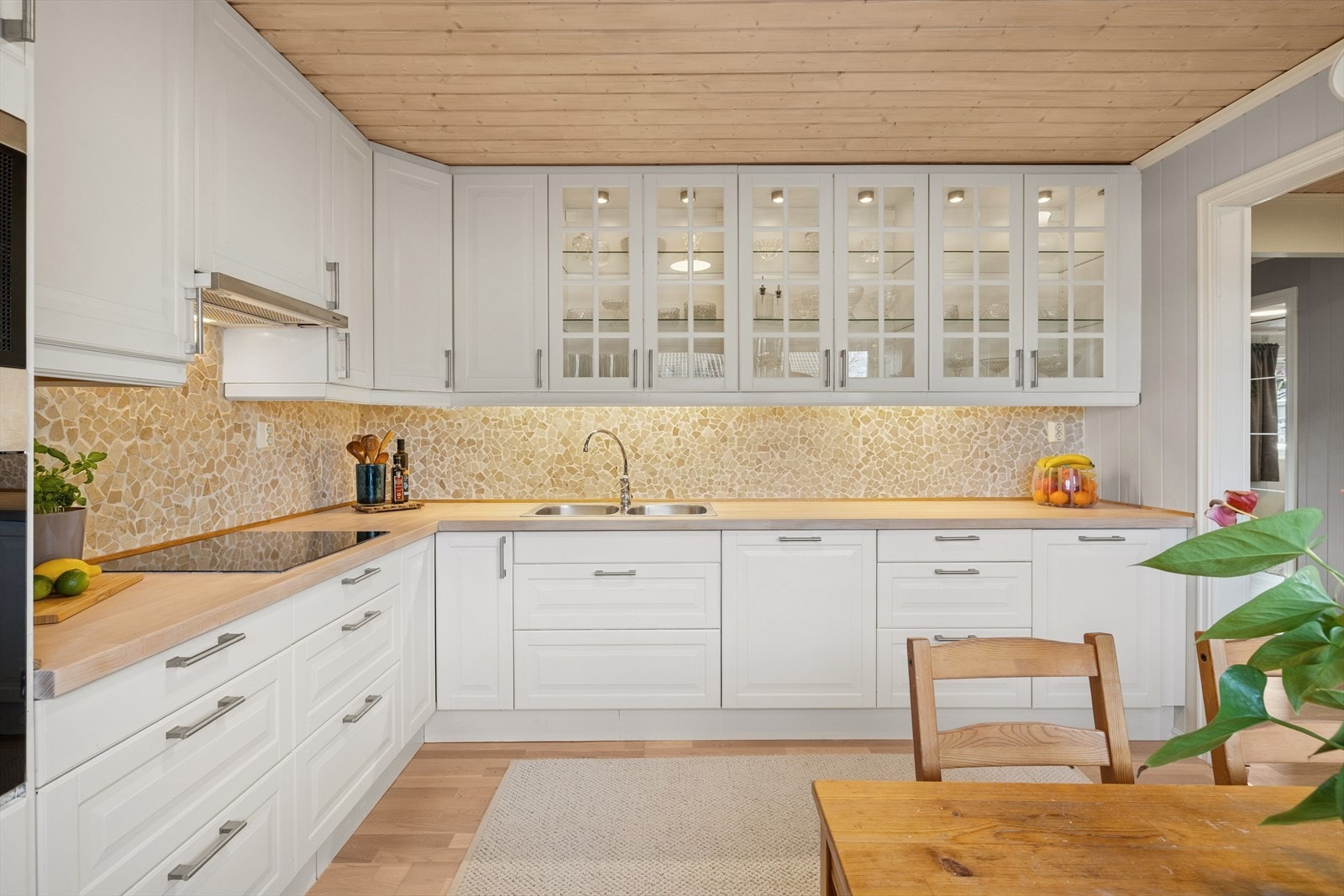 Det er godt med skuffer, skap- og benkeplass på kjøkkenet. Det er en nedfelt kum av stål, og veggen over benken er kledd med fliser. Galleribilde