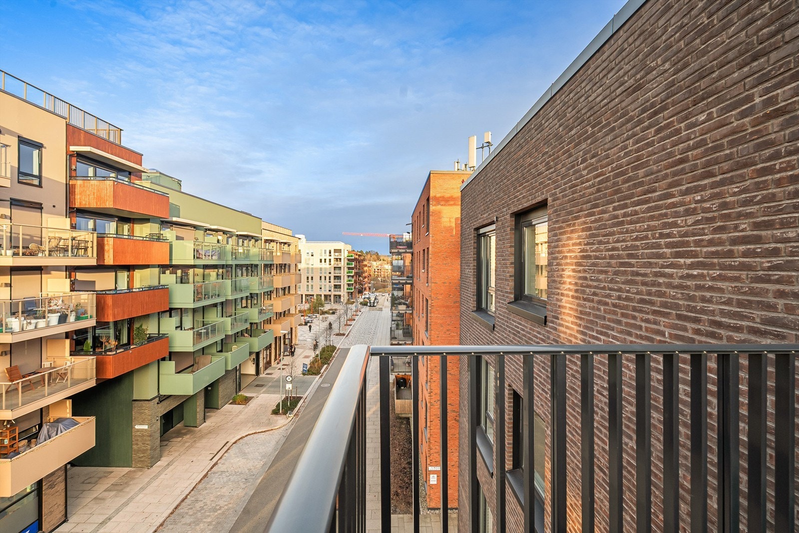 Fra hybelbalkongen har man også sikt mot Vollebekk torg som i 2025 mottok Oslo bys arkitekturpris. Her er det hyggelige uteomgivelser samt café og restaurant. Galleribilde