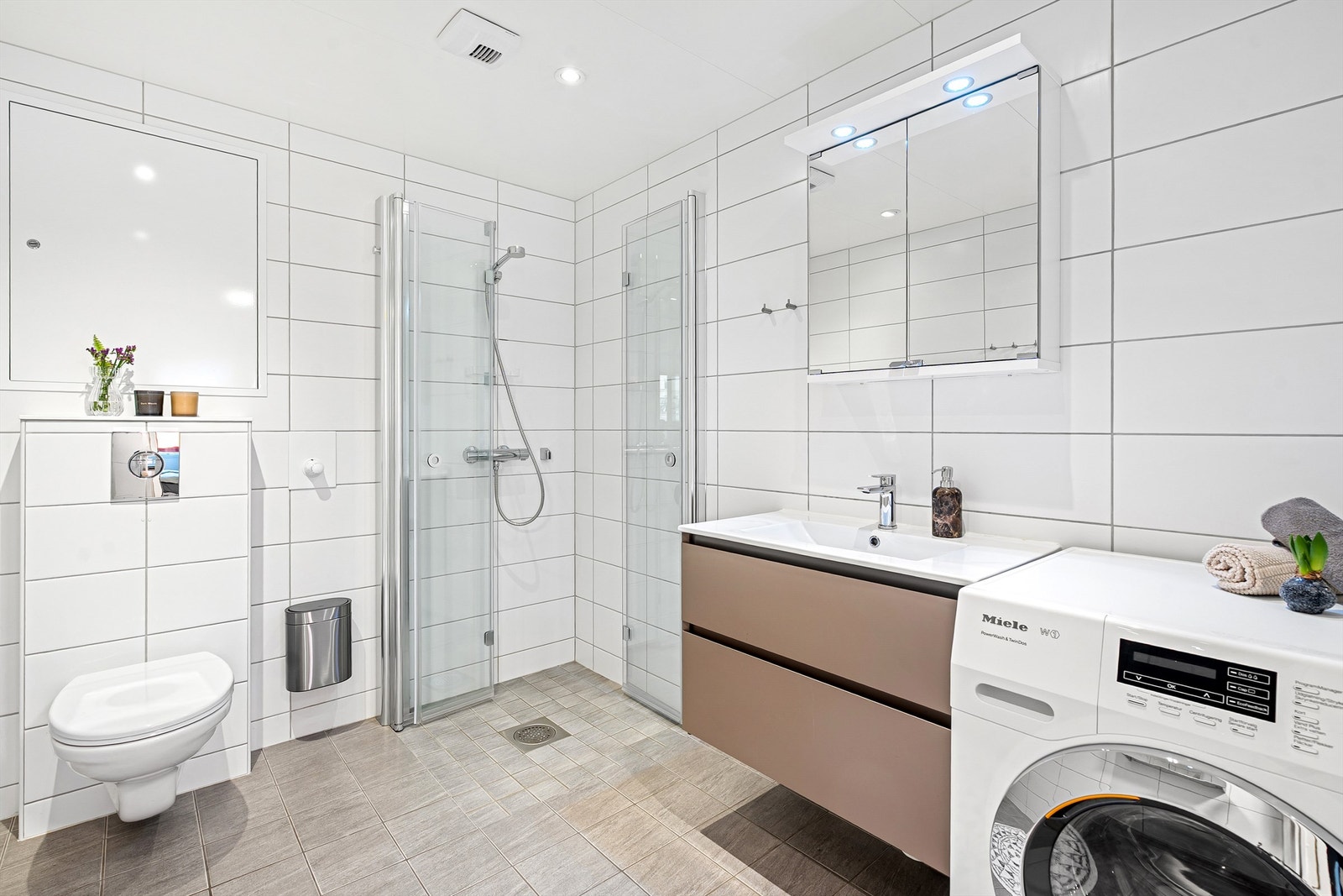 Flislagt baderom med gulvvarme og opplegg for vaskemaskin. Galleribilde