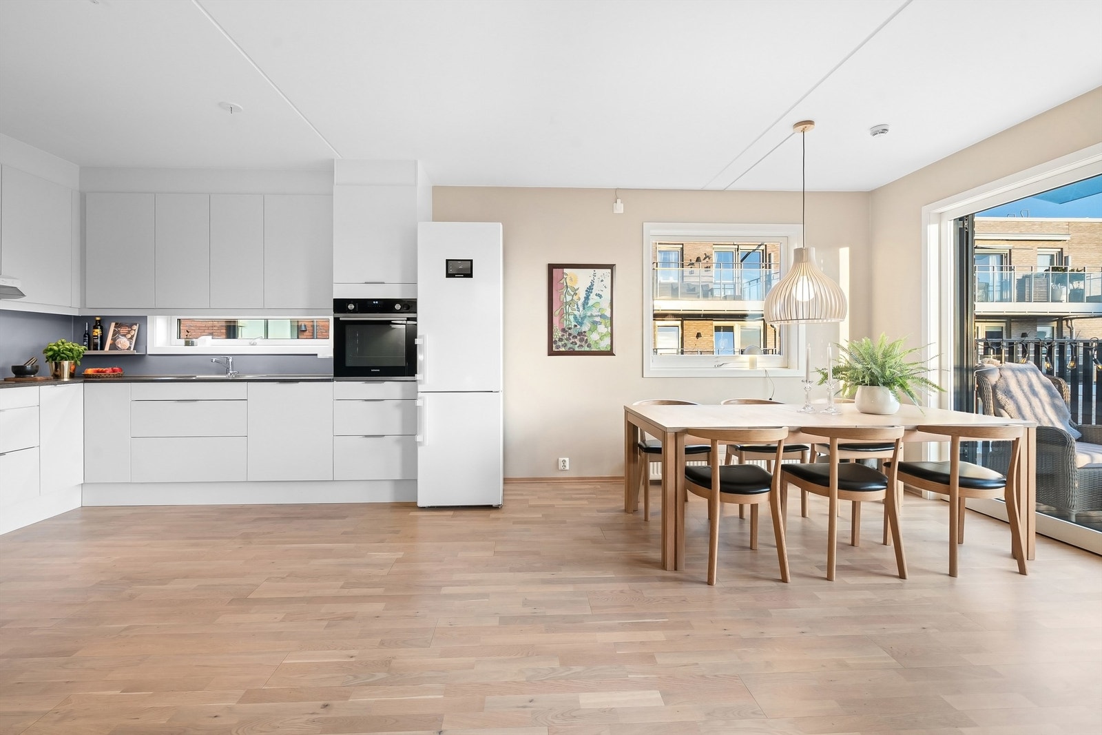 Spisebord med naturlig plassering mellom kjøkken og stue. Galleribilde