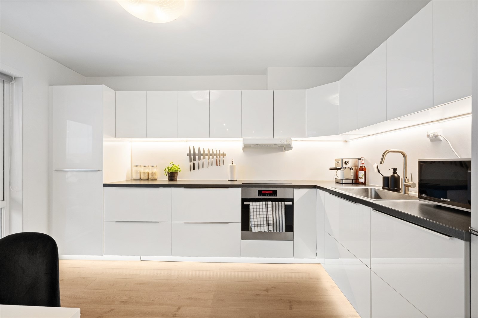 Moderne kjøkken med stilrent design og praktiske løsninger, perfekt for matlaging og sosiale sammenkomster i hjemmet. Galleribilde