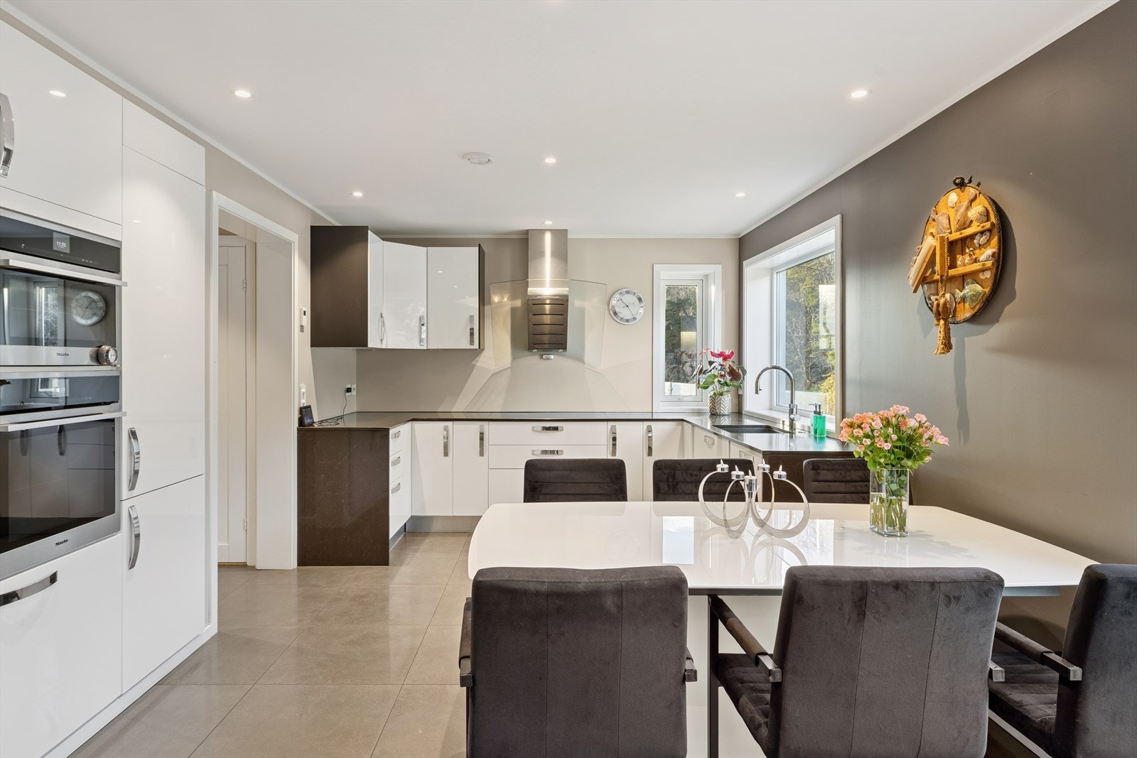 Pent kjøkken med integrerte hvitevarer; induksjonstopp 90 cm, oppvaskmaskin, stekeovn, dampovn, varmeskuff, micro, kaffemaskin, kjøleskap og fryseskap. Galleribilde