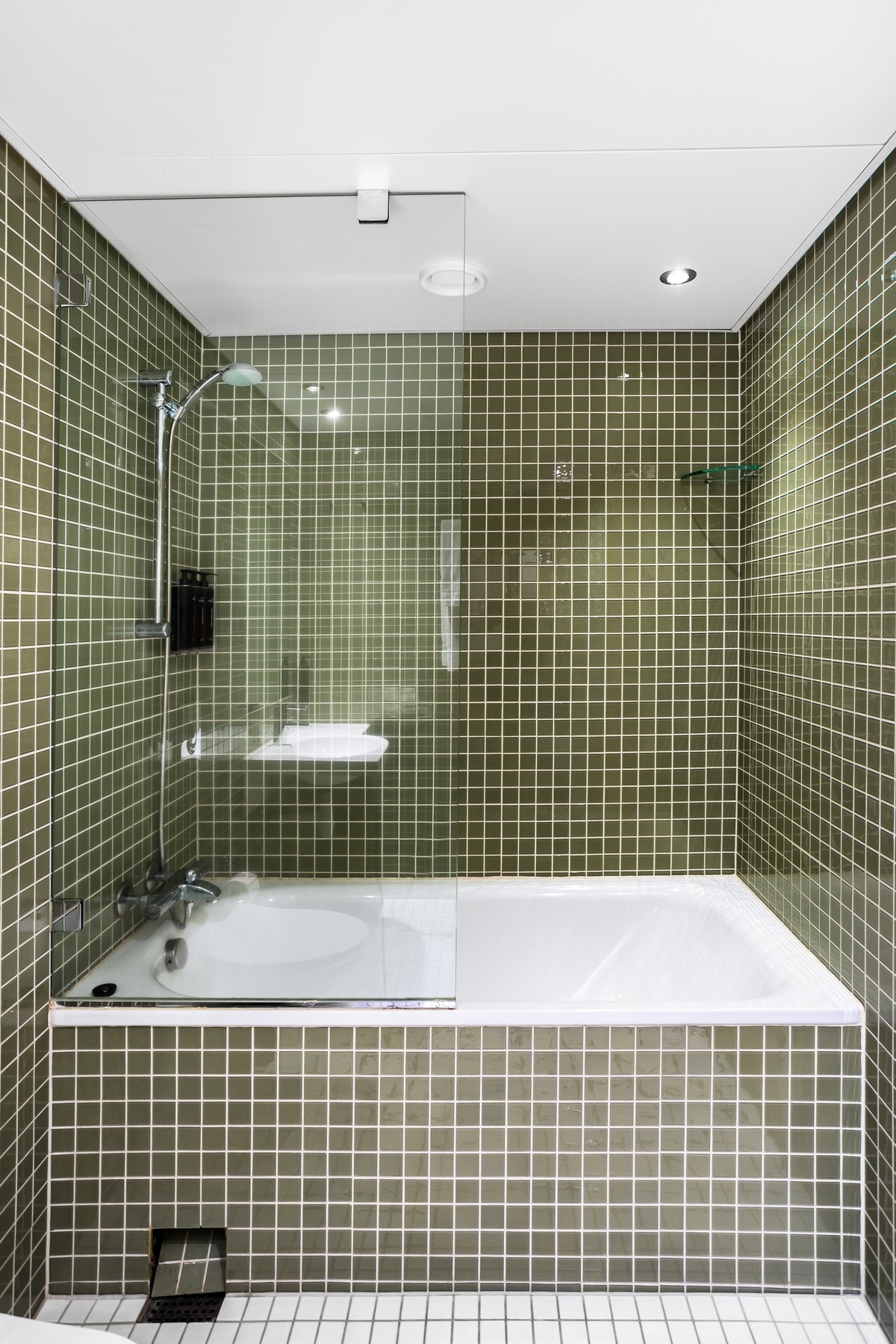 Badet har lyse fliser på både gulv og vegg, gulvvarme og downlights. Galleribilde