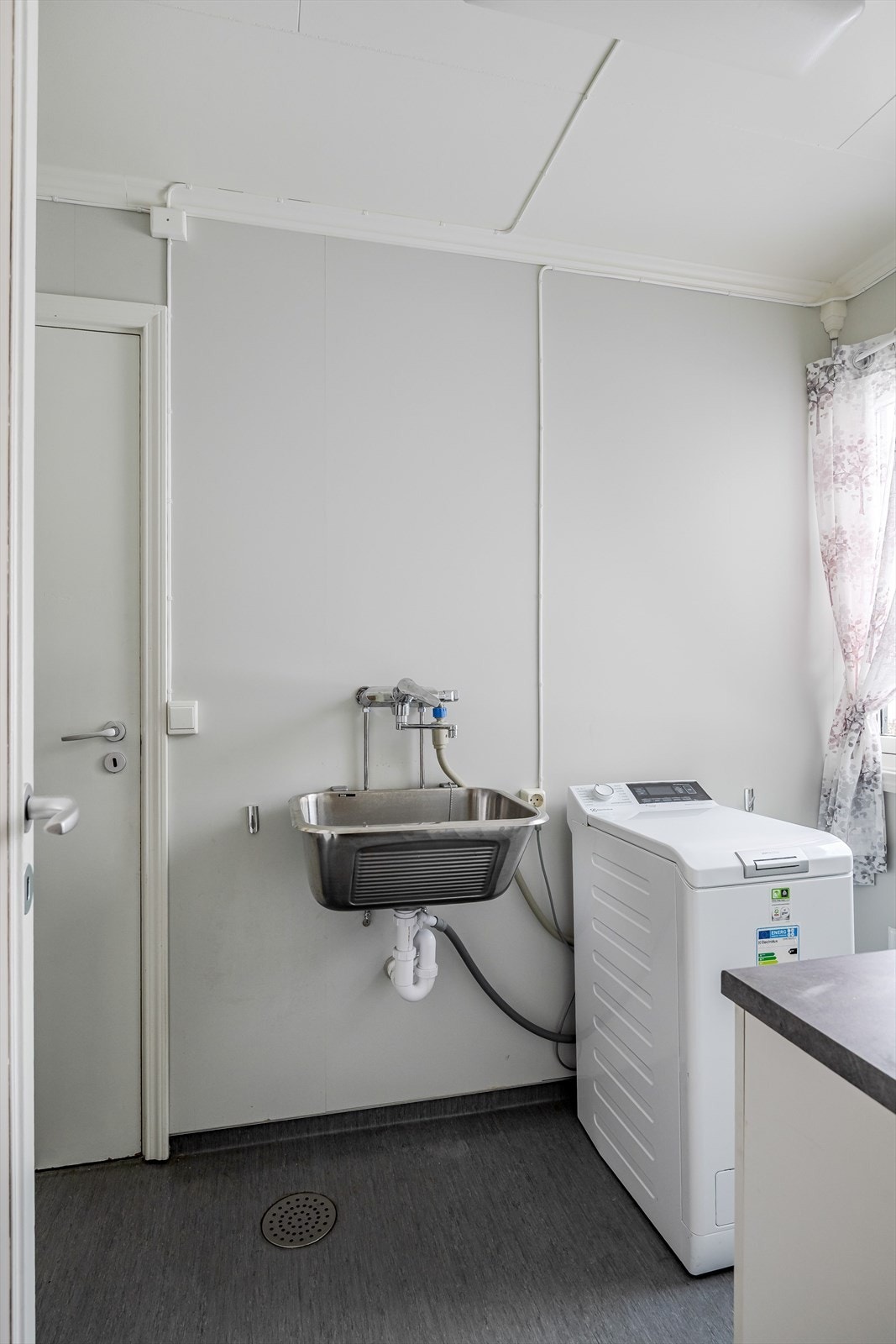 Både fra entréen og kjøkkenet er det adkomst til et praktisk vaskerom med belegg på gulv og våtromsplater på veggene. Galleribilde