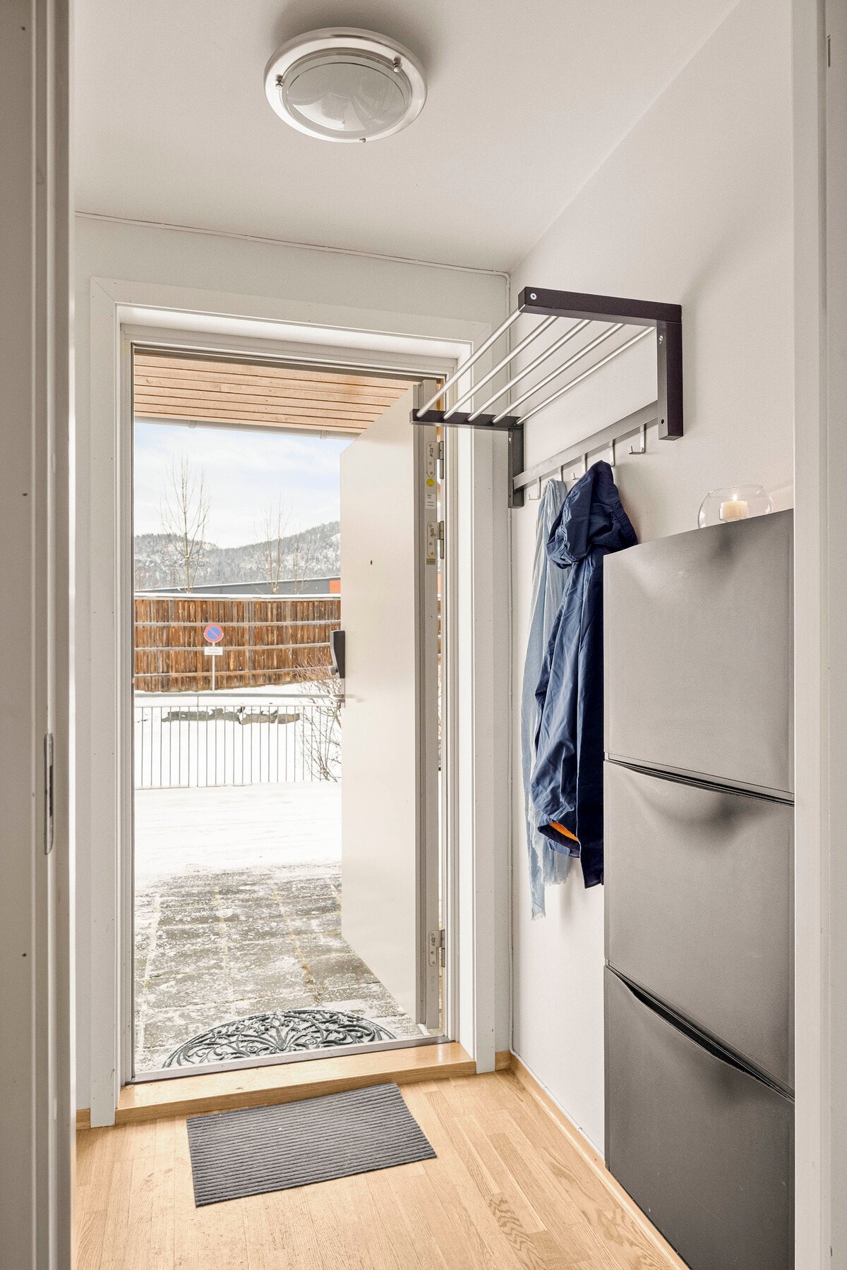 Leiligheten har en entré/ vindfang hvor man kan henge fra seg yttertøy og sette fra seg sko i et montert skoskap. Galleribilde