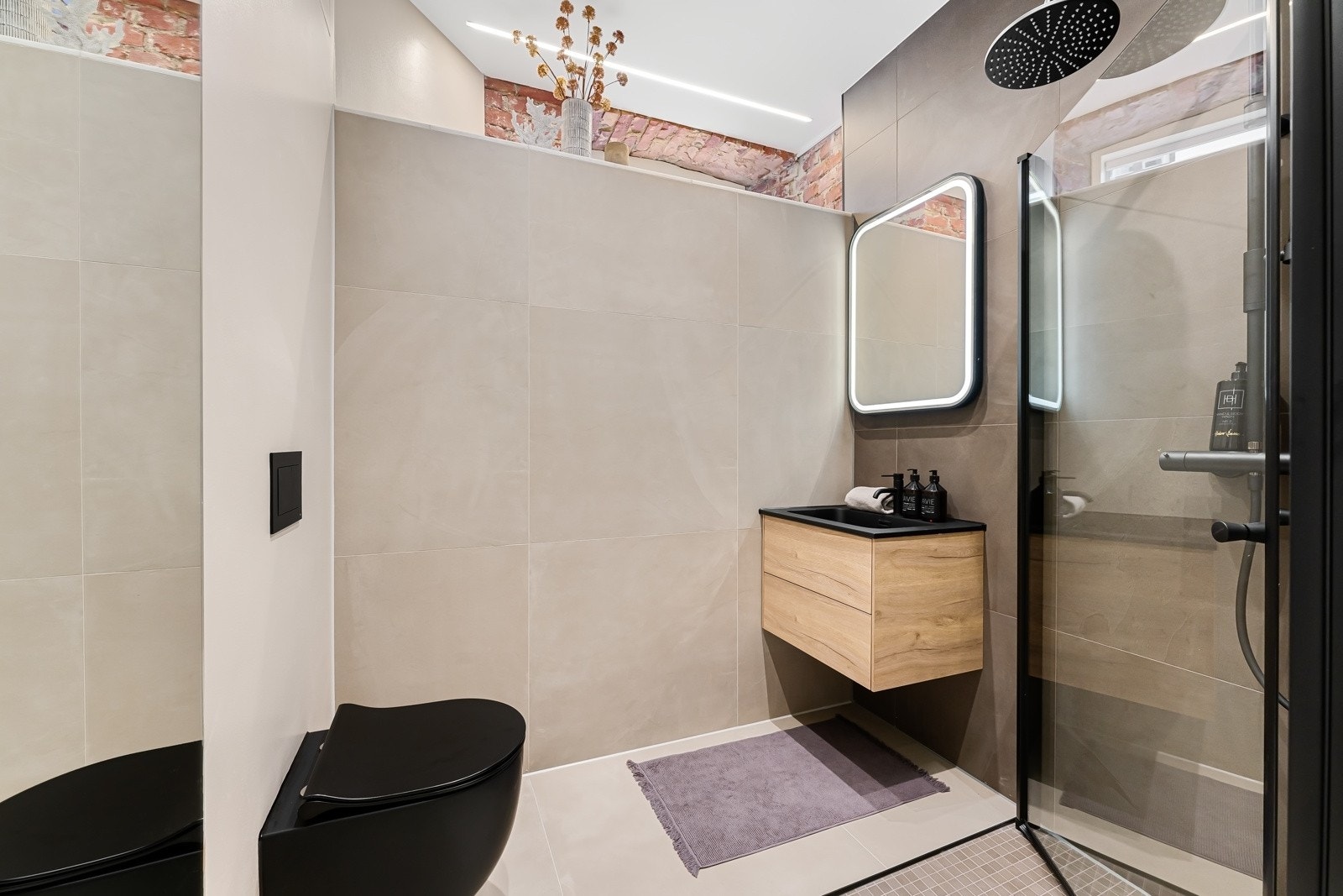 Delikat velværebad fra 2023 med store vegg- og gulvfliser, downlights i himling og vannbåren varme. Galleribilde