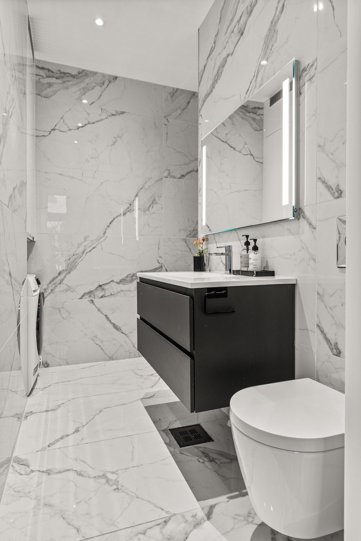 Eksklusivt og moderne bad med lekre marmorfliser på både gulv og vegger. Rommet fremstår som både luksuriøst og funksjonelt. Galleribilde