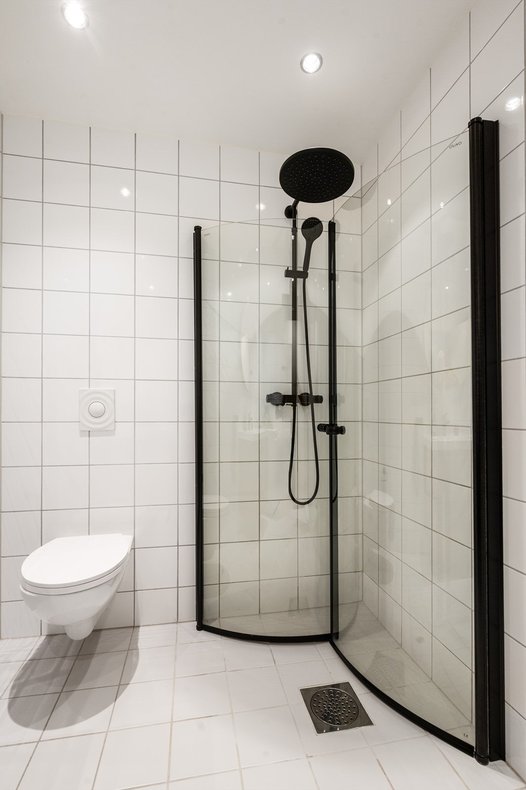 Badet er utstyrt med vegghengt klosett og dusjhjørne med svingbare glassdører. Galleribilde