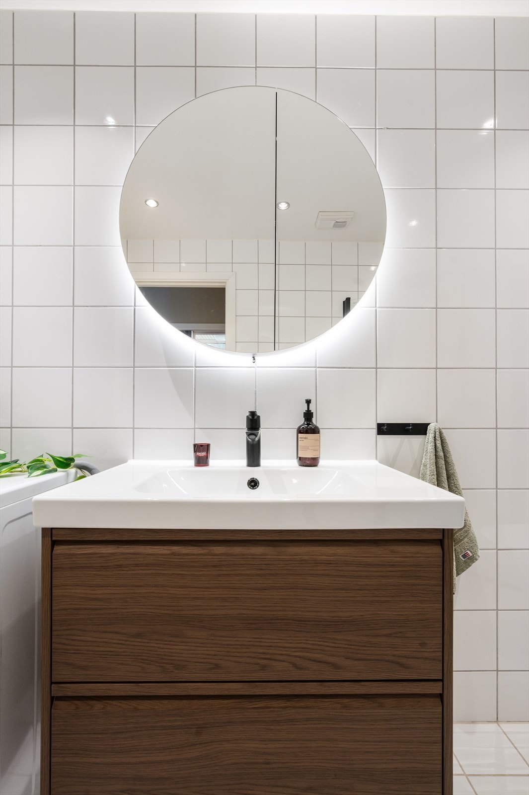 Ny og moderne baderomsinnredning med servant, god skapplass og praktisk speil med integrert belysning. Galleribilde