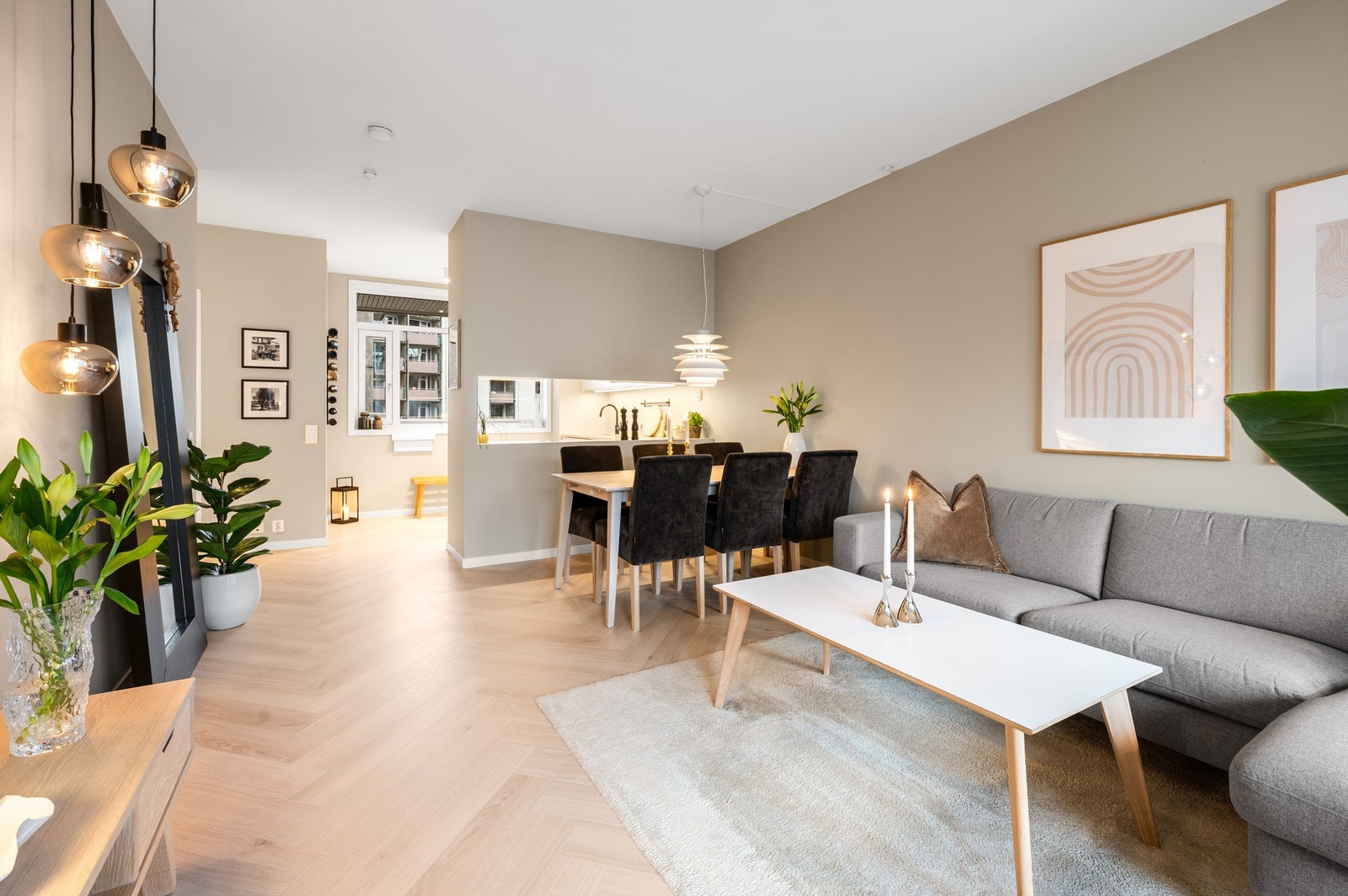 Stue og kjøkken i en delvis åpen løsning skaper en sosial og luftig atmosfære. Galleribilde