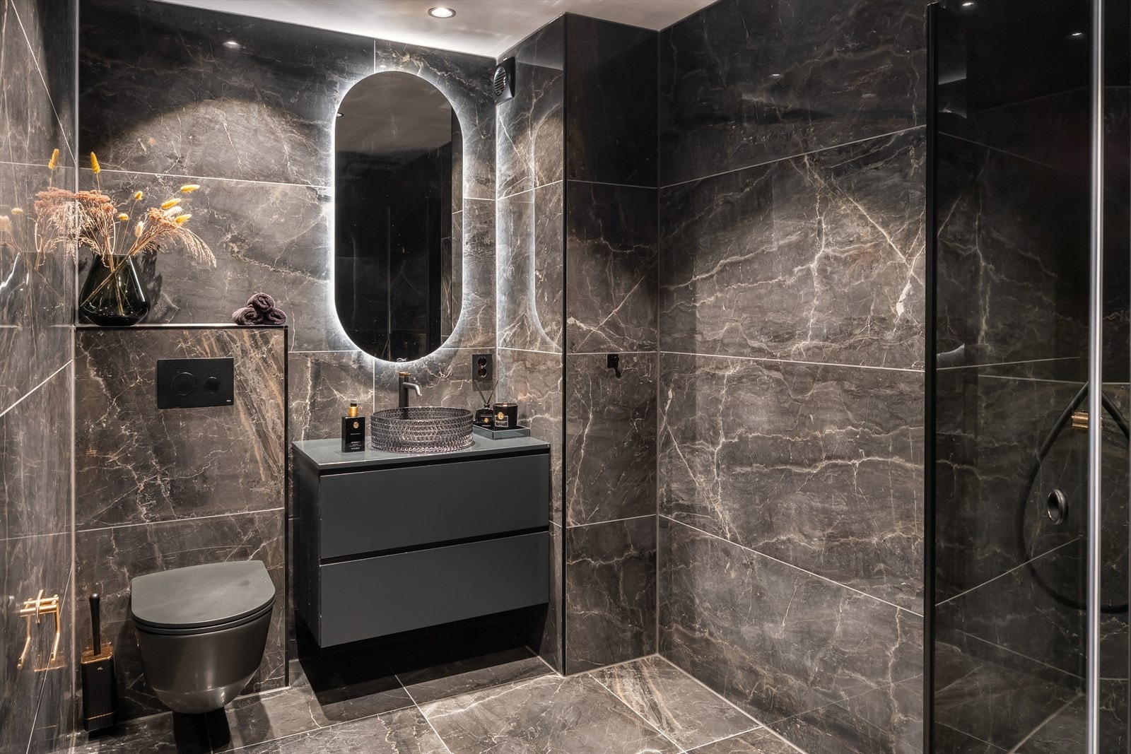 Påkostet og totaloppusset marmorinspirert bad på 4,6 m² fra 2023 med eksklusivt uttrykk og sorte detaljer. Galleribilde