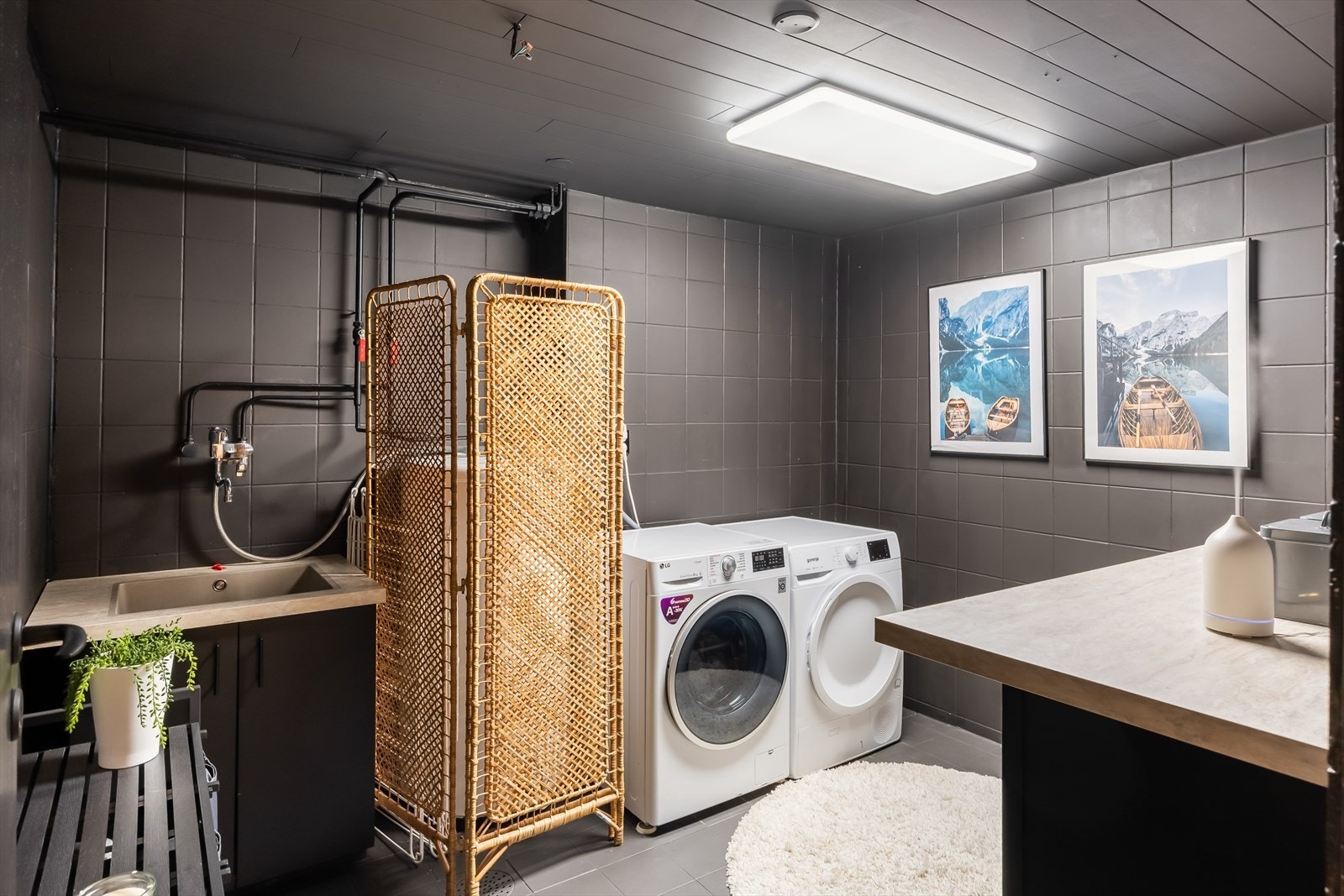 Praktisk flislagt vaskerom på 7,7 m² med opplegg for vaskemaskin og tørketrommel. Galleribilde