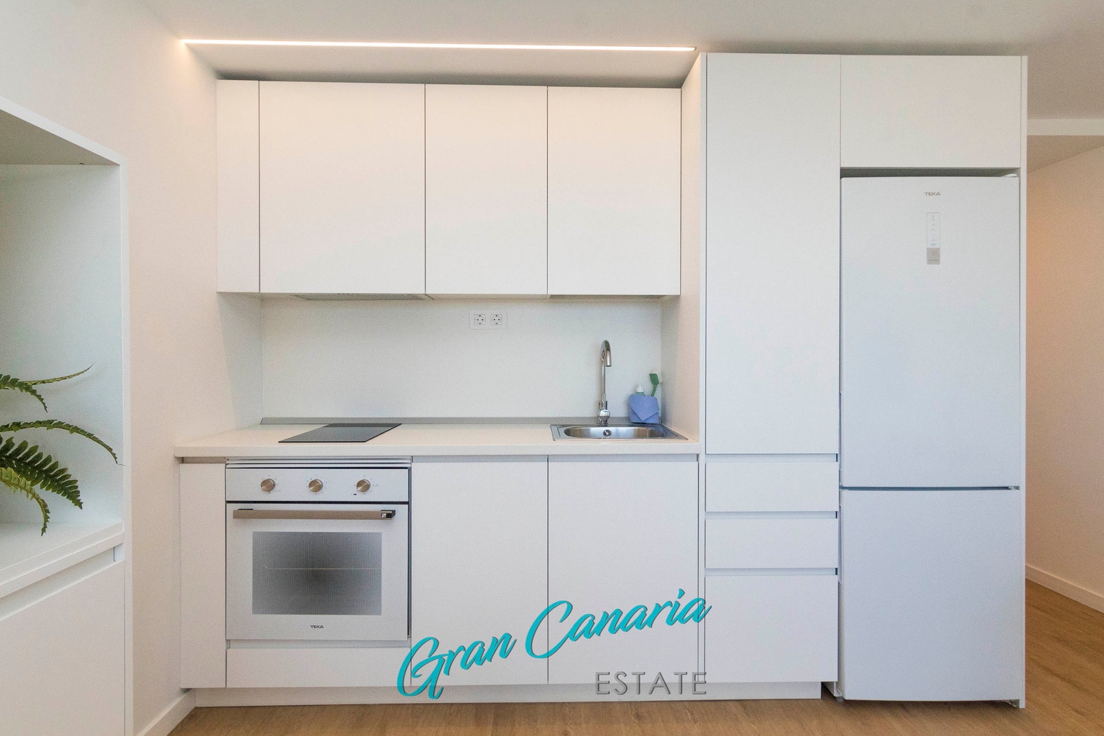 Pen kjøkkeninnredning med det kjøl/frys, komfyr, induksjonstopp etc Galleribilde